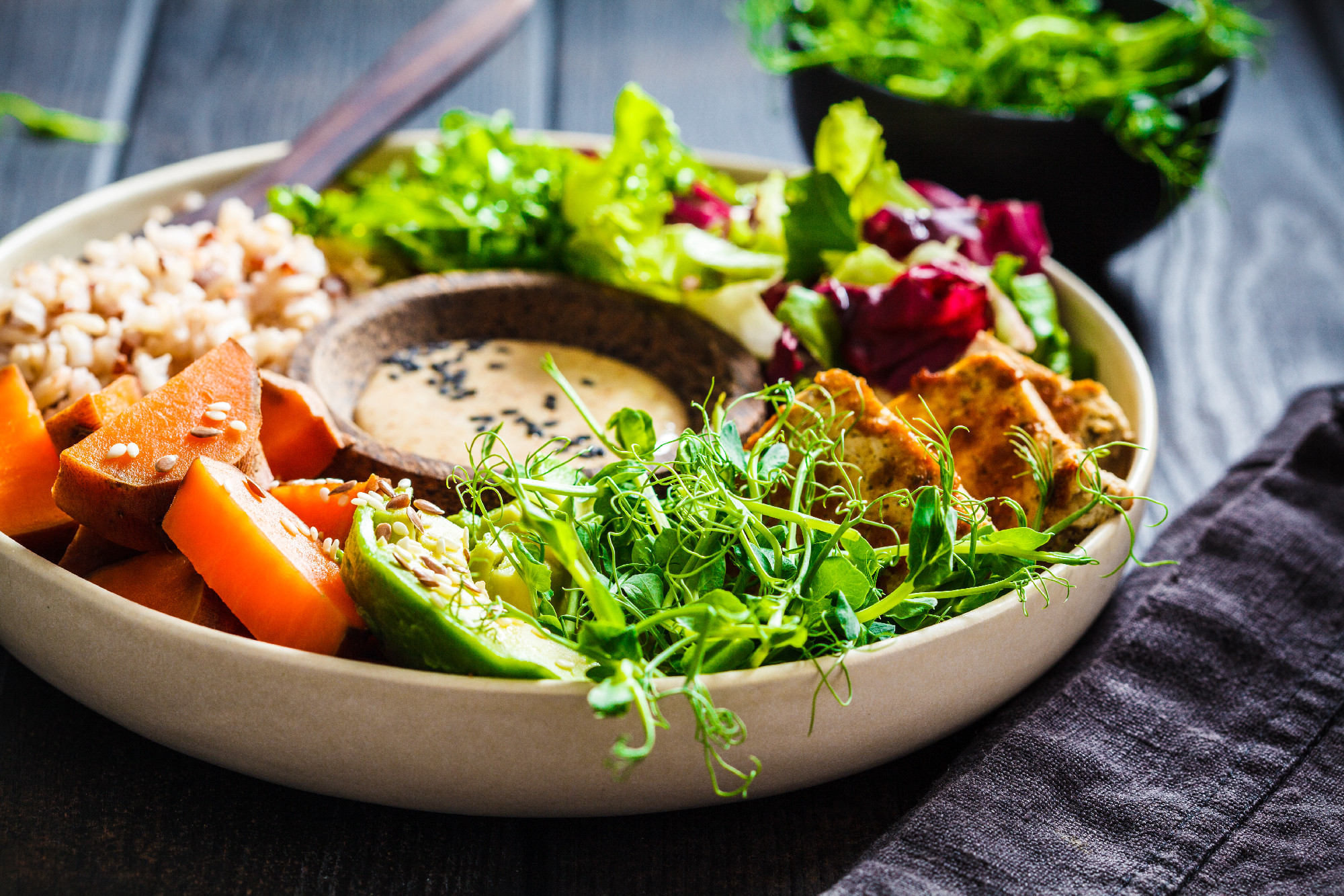 Buddha bowl with tofu, avocado, rice, seedlings, sweet potato an