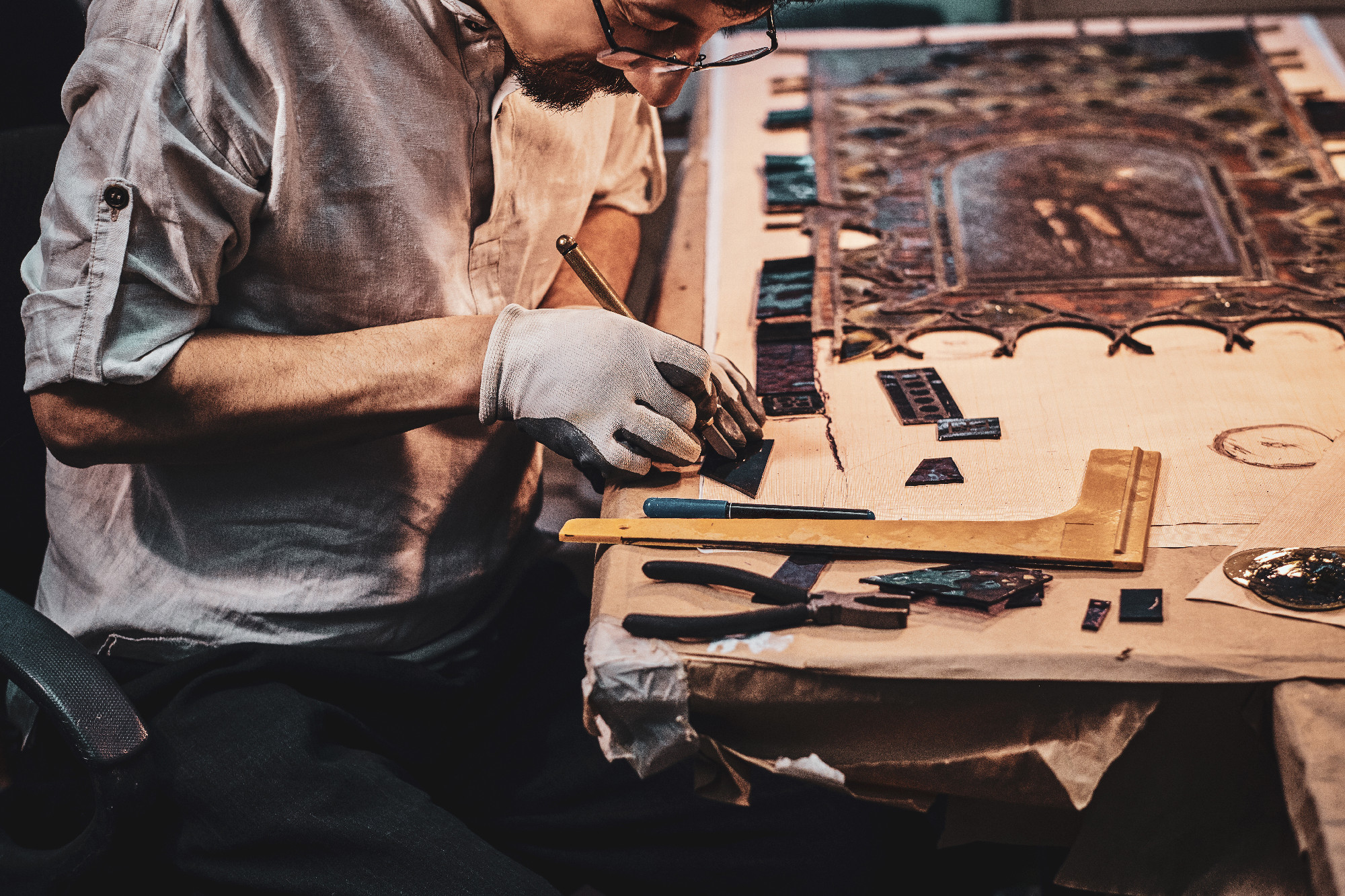 Expirienced diligent man is working on stained glass restoration