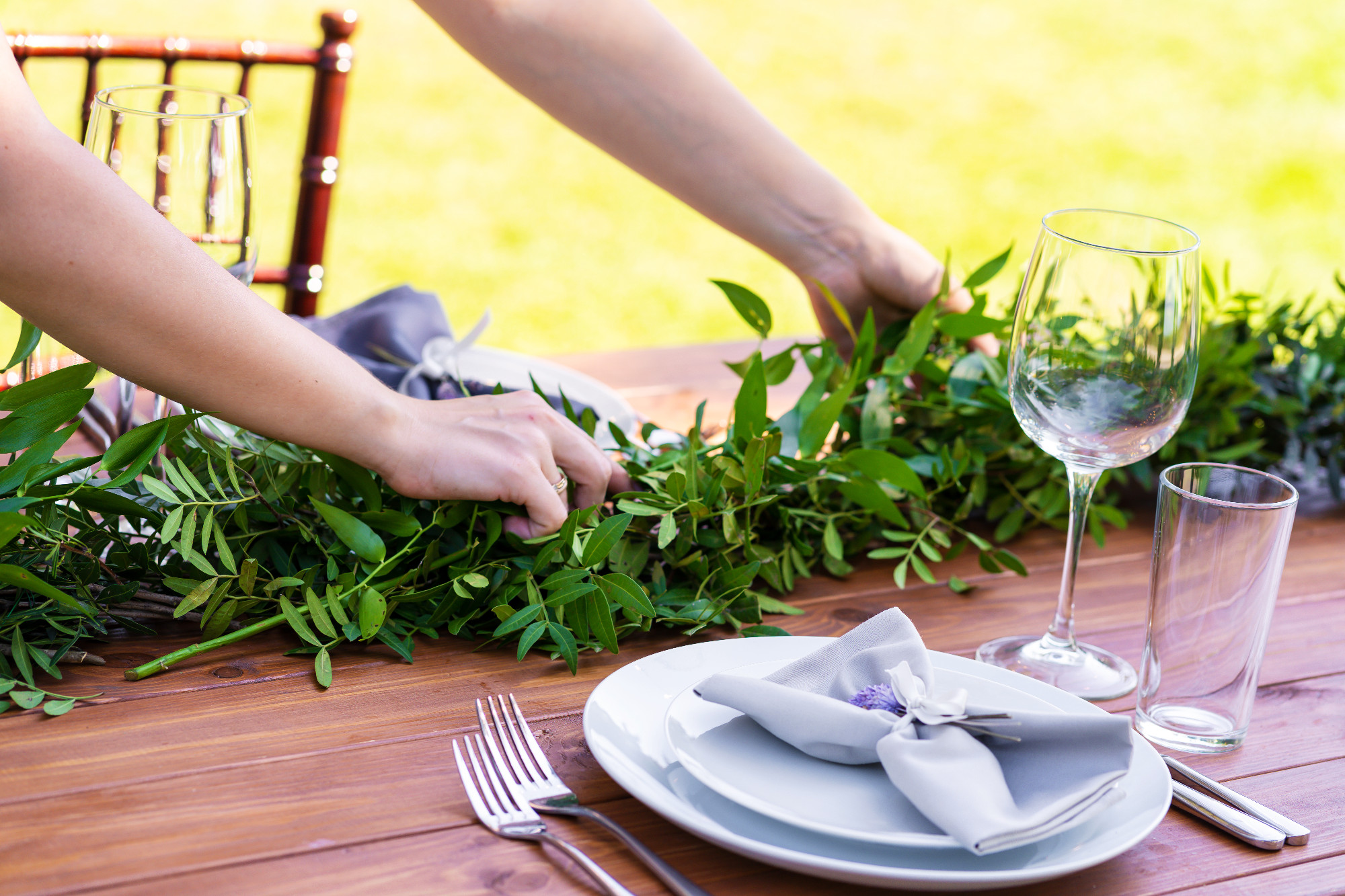 Preparing for an open-air party. Girl decorates tables with fres
