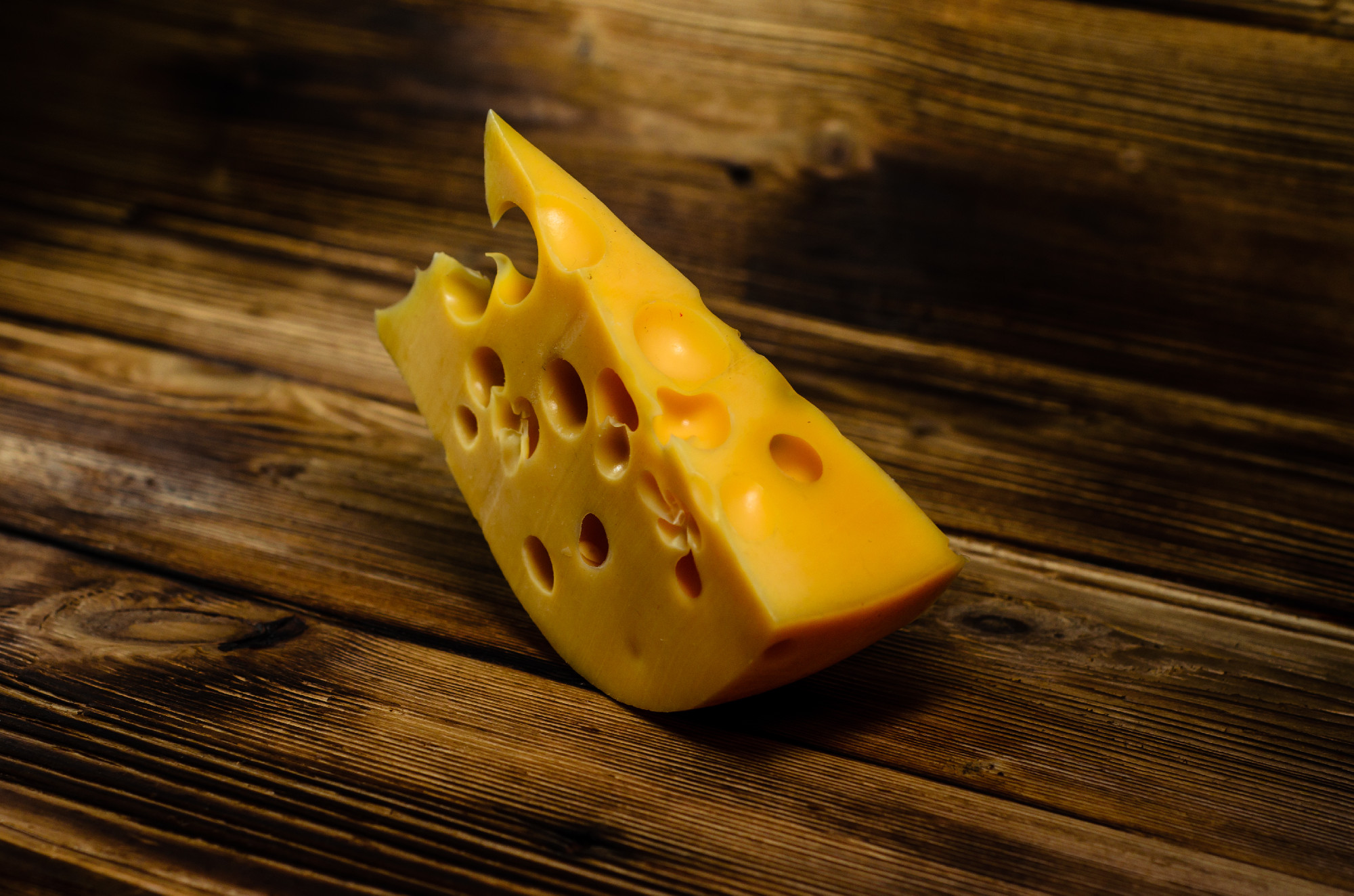 Piece of cheese on wooden table