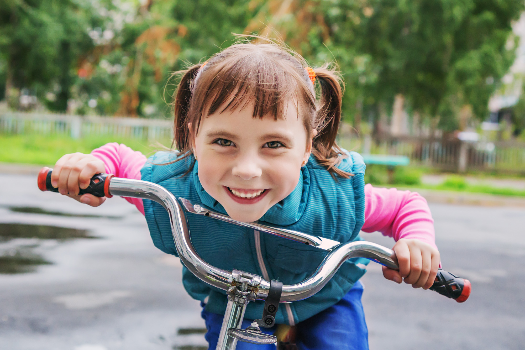 Smiling little girl on a bicycle.