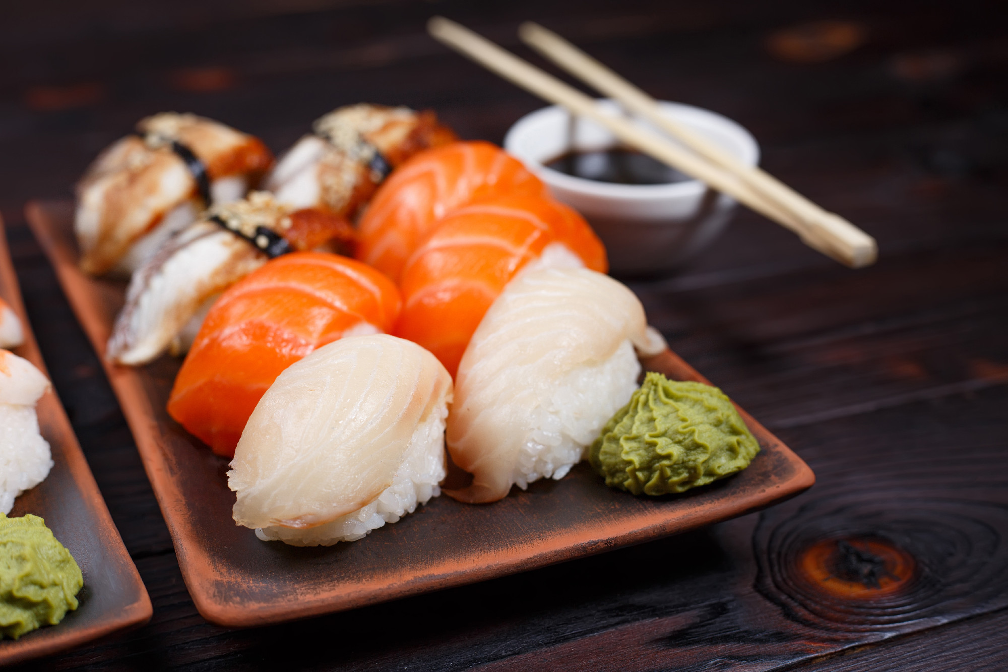 Delicious appetizing nigiri sushi, served on clay plates with so