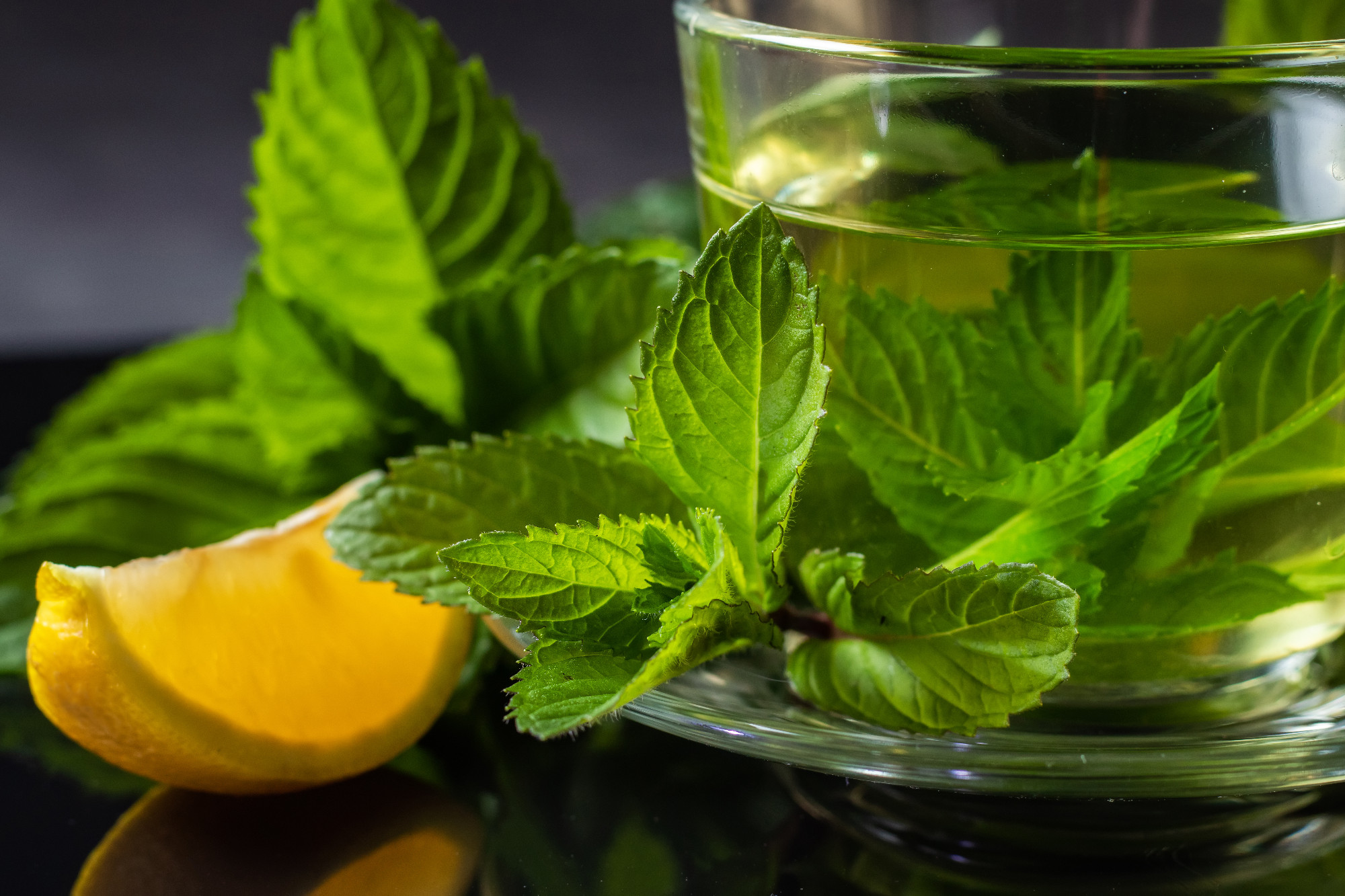 Close-up cup of mint tea with fresh leaf of mint and lemon.
