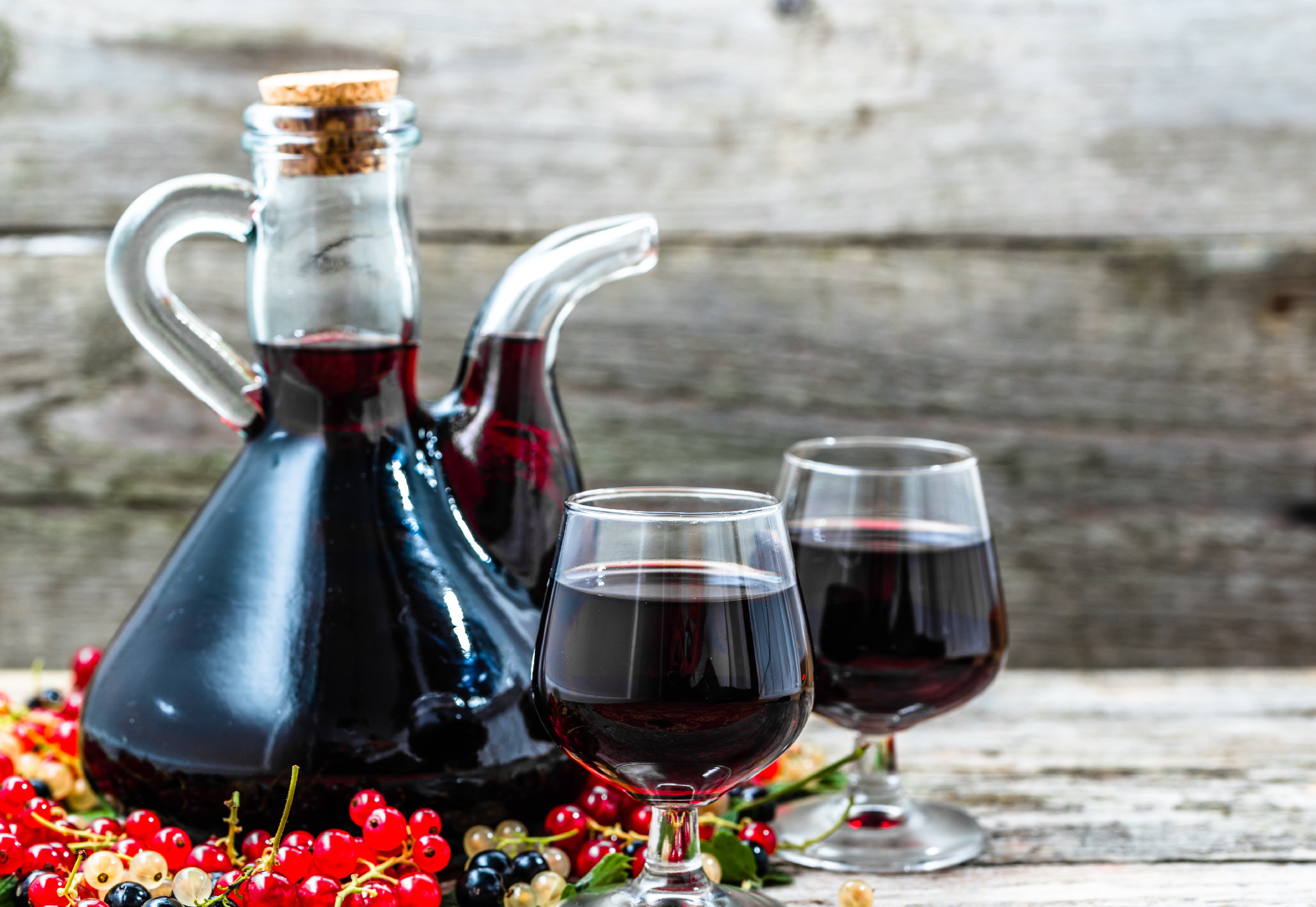 Old wine carafe on wooden table. Sweet alcohol made from fruits