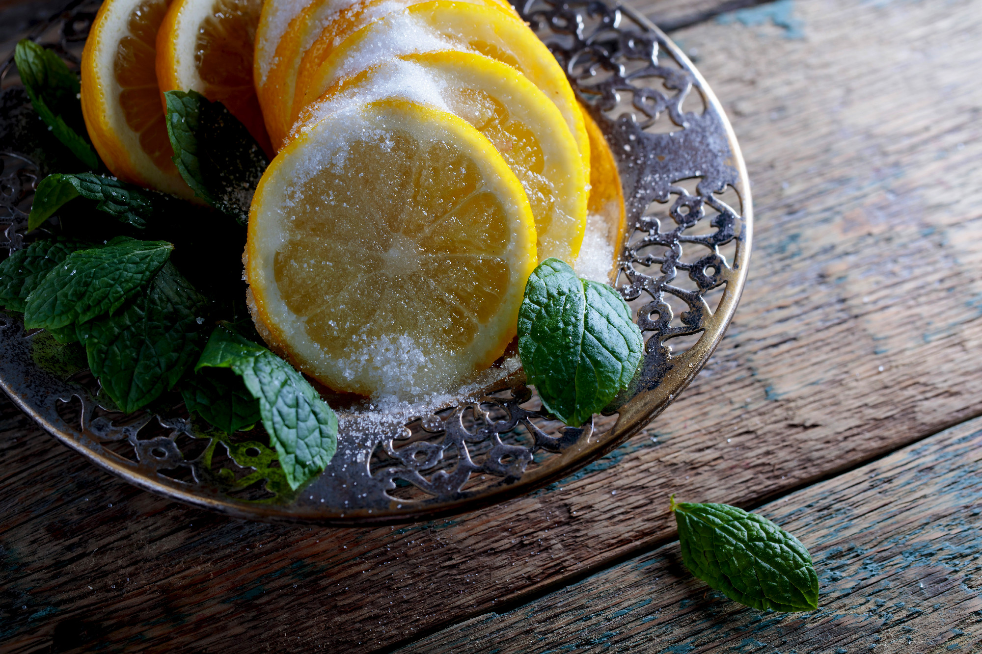 Lemon slices with sugar and mint leaves.