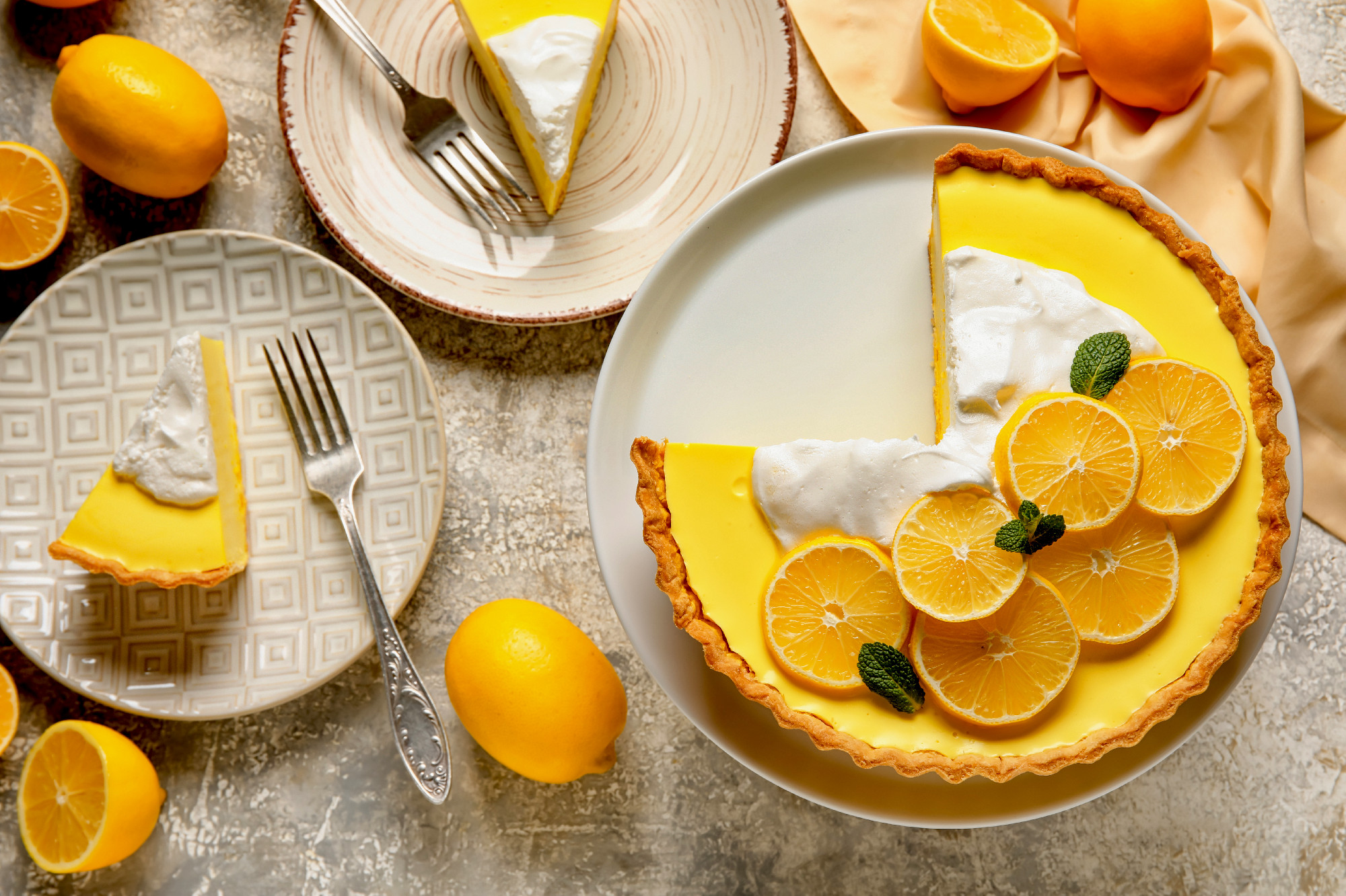 Stand and plates with tasty baked lemon pie on light background