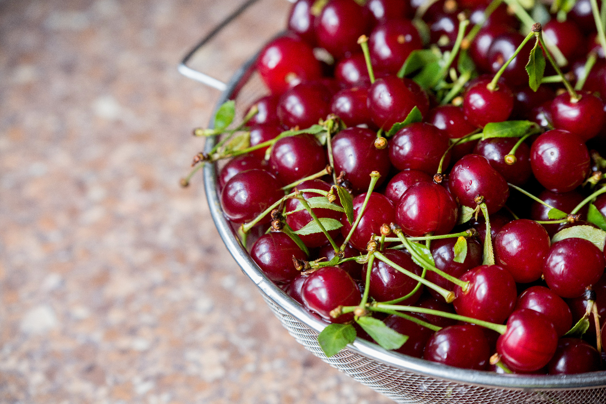 Cherries in a steel sieve. top view, texture
