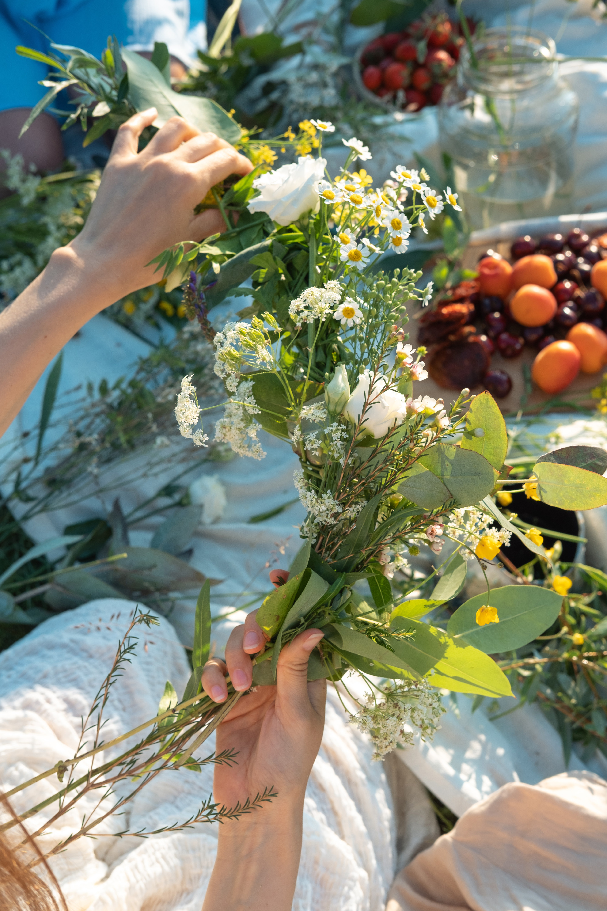 Unrecognized woman weaves a wreath of wild flowers for the summe