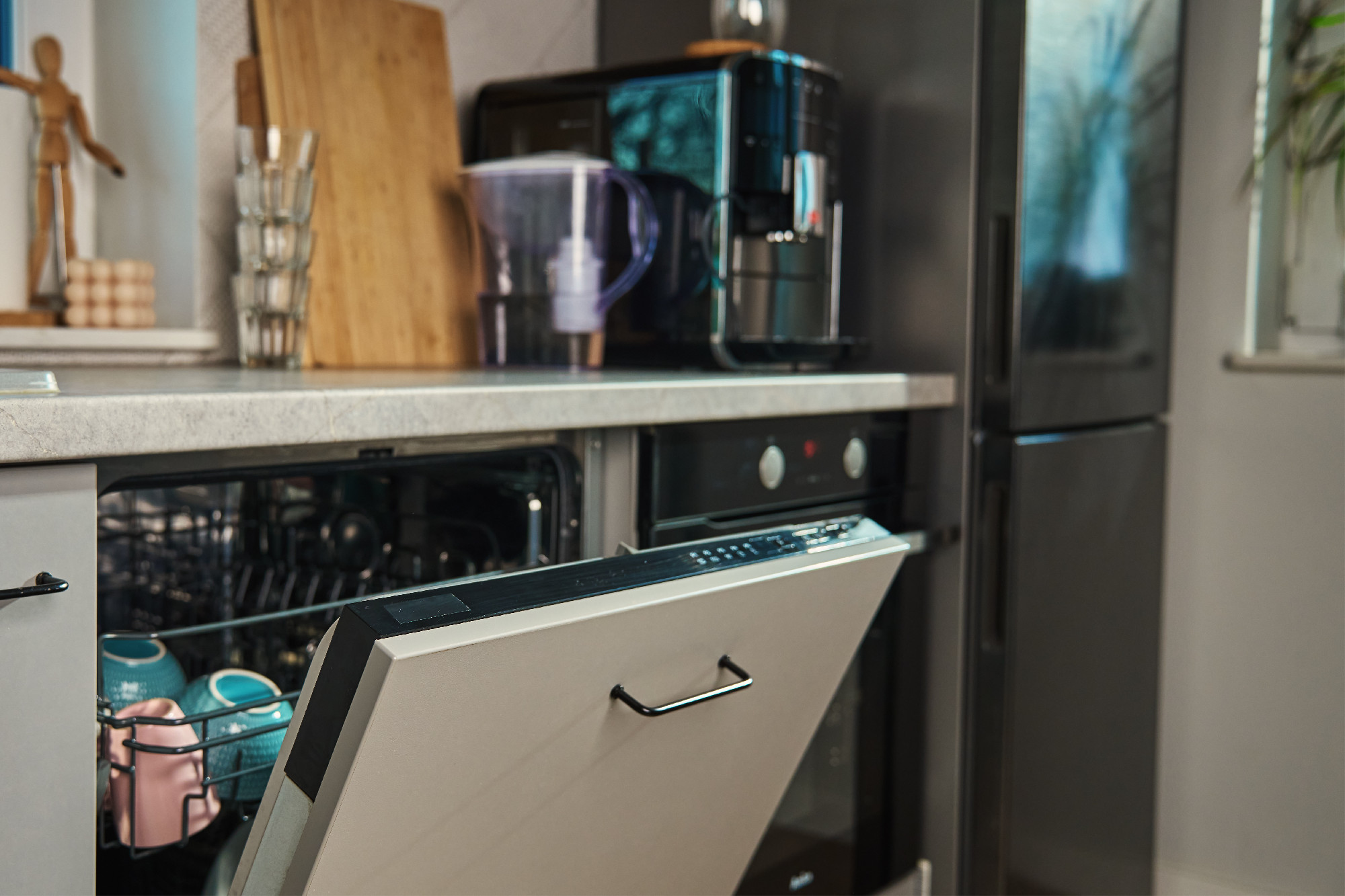 Open dishwasher with clean dishes in modern kitchen