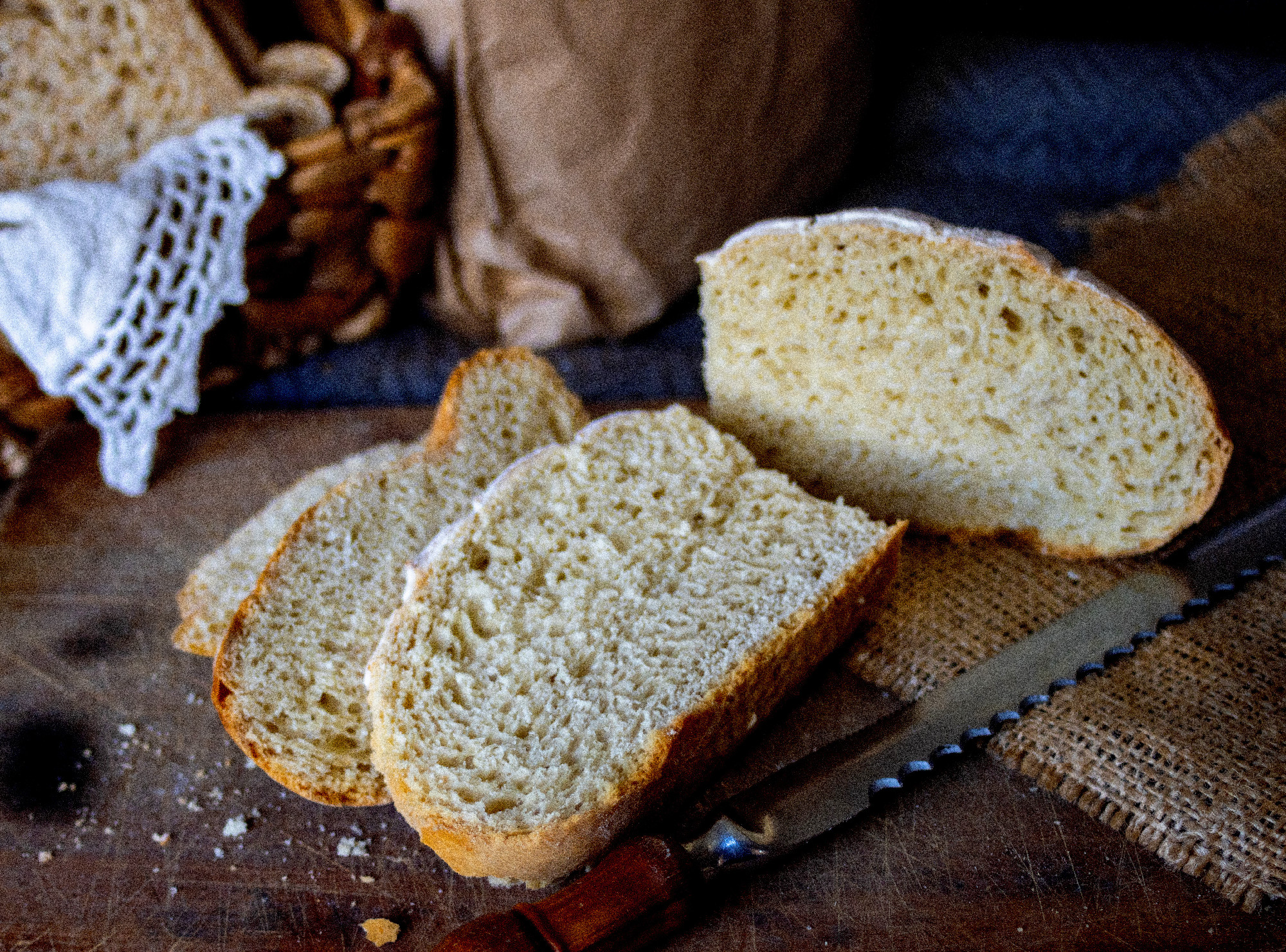 Artisan bread slices on a wooden background. Real photo.
