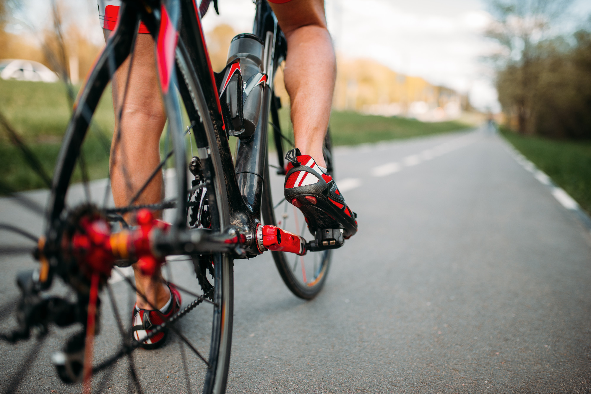 Bycyclist on bike path, view from the rear wheel