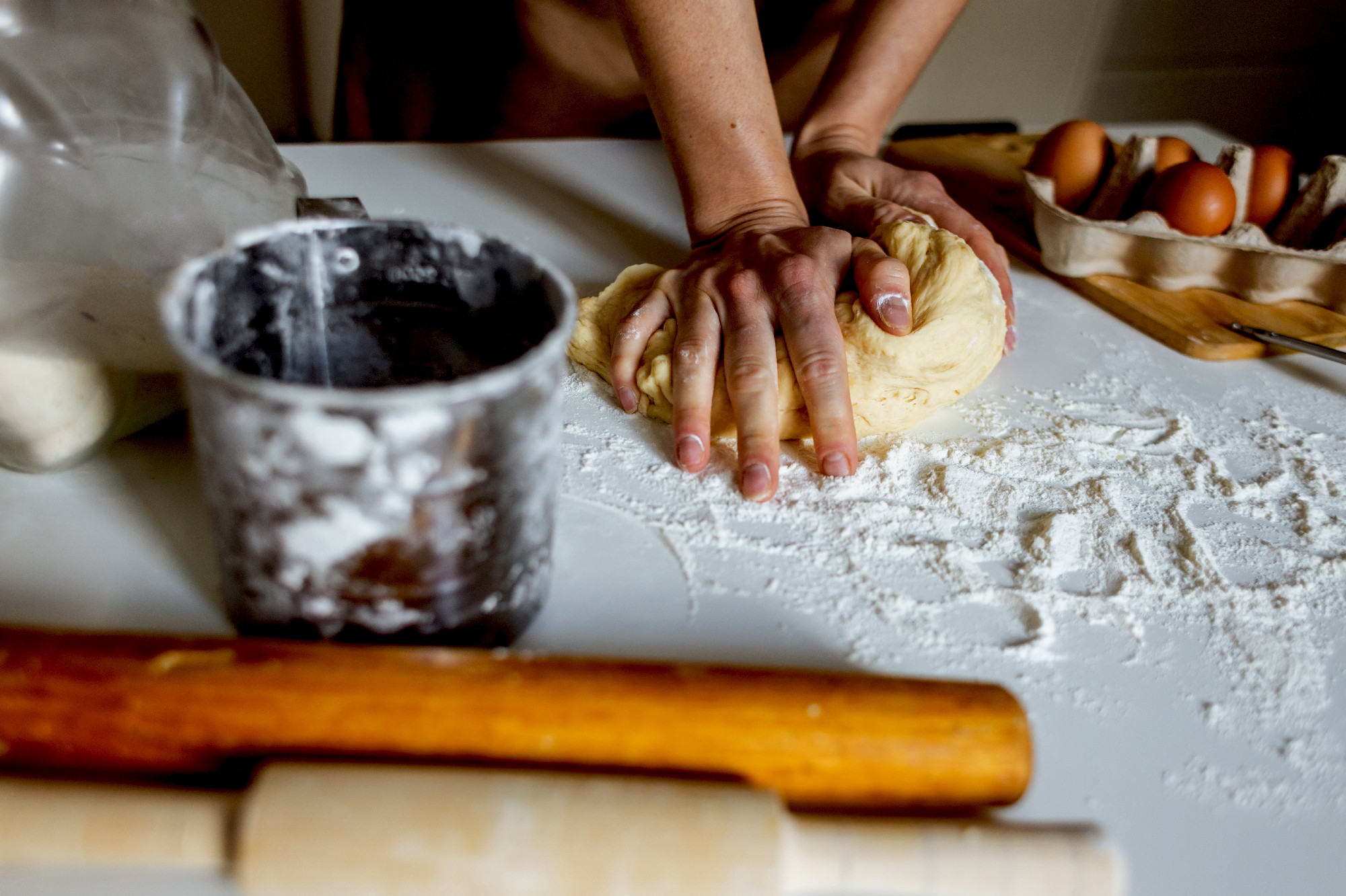 A woman in an apron prepares dough for baking at home. Rolling o
