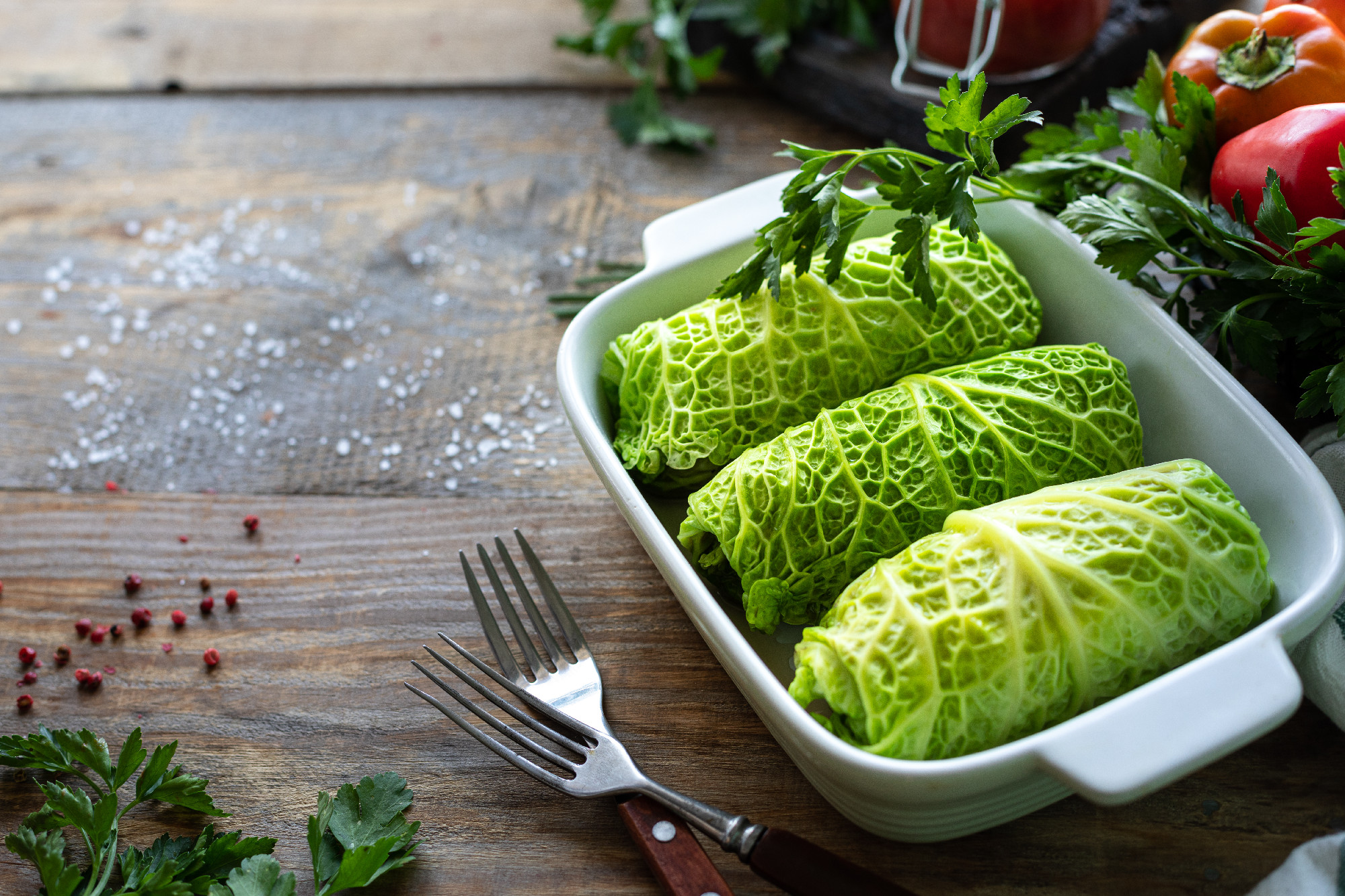 savoy cabbage rolls stuffed with meat, rice and vegetables on a rustic table