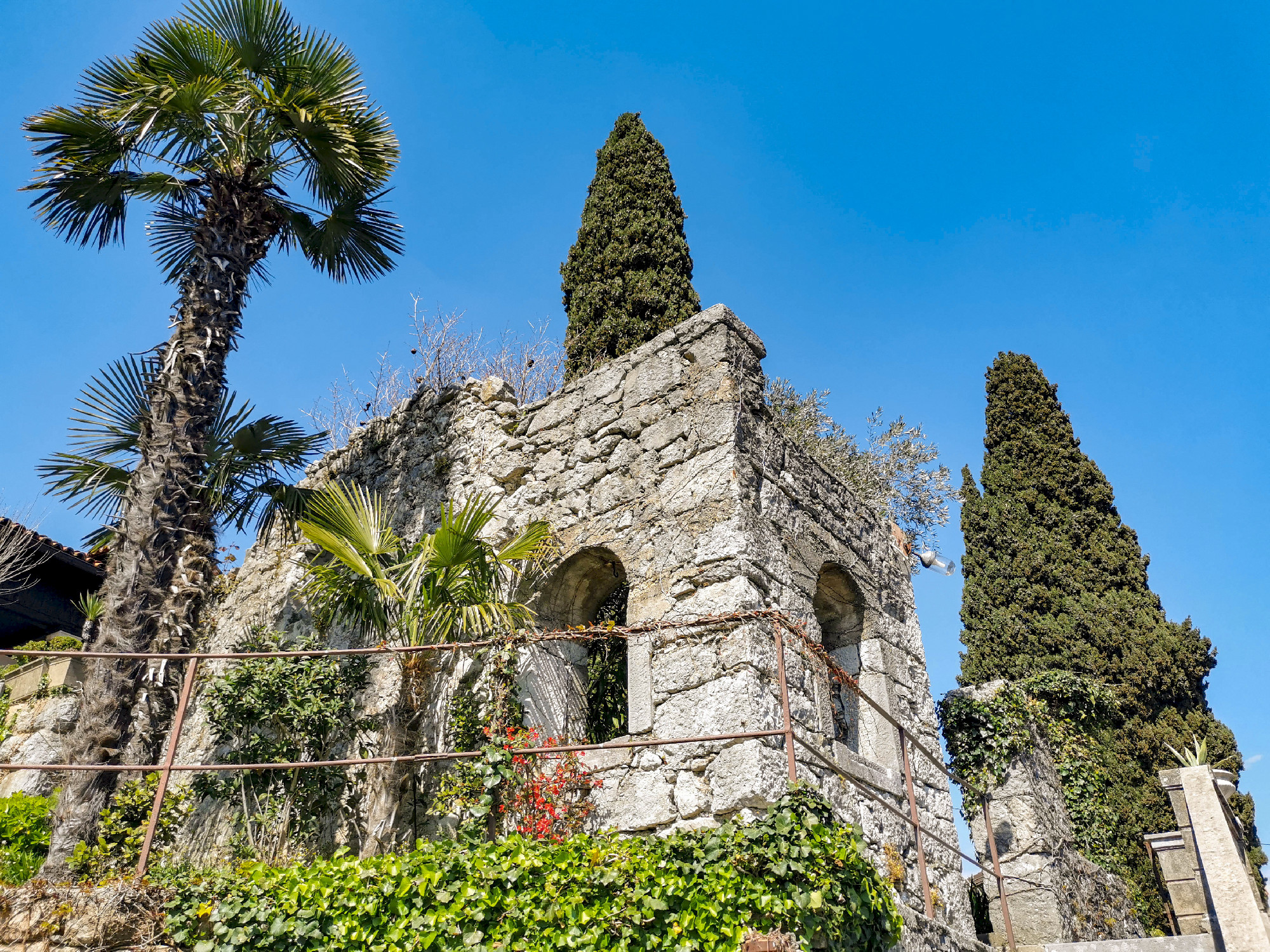 Stone structures and greenery in landscape gardens on sunny day in spring in Opatija, Croatia.