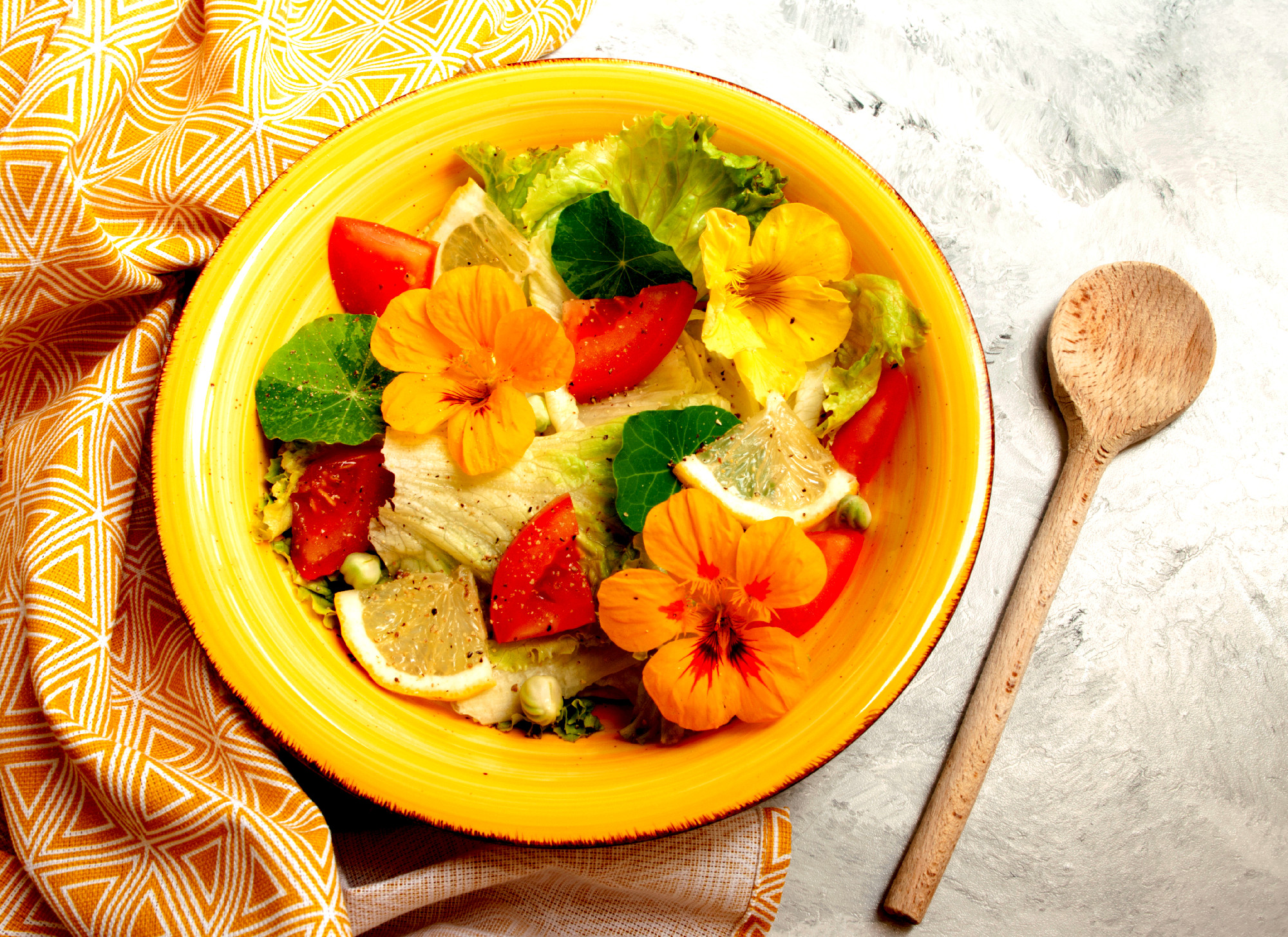 nasturtium flowers salad with tomatoes and lemones in yellow cer