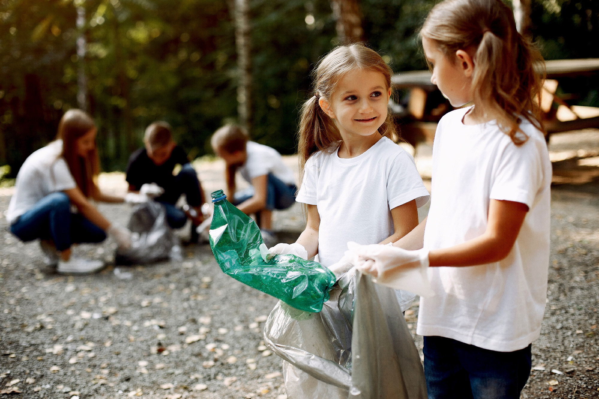 Children collects garbage in garbage bags in park