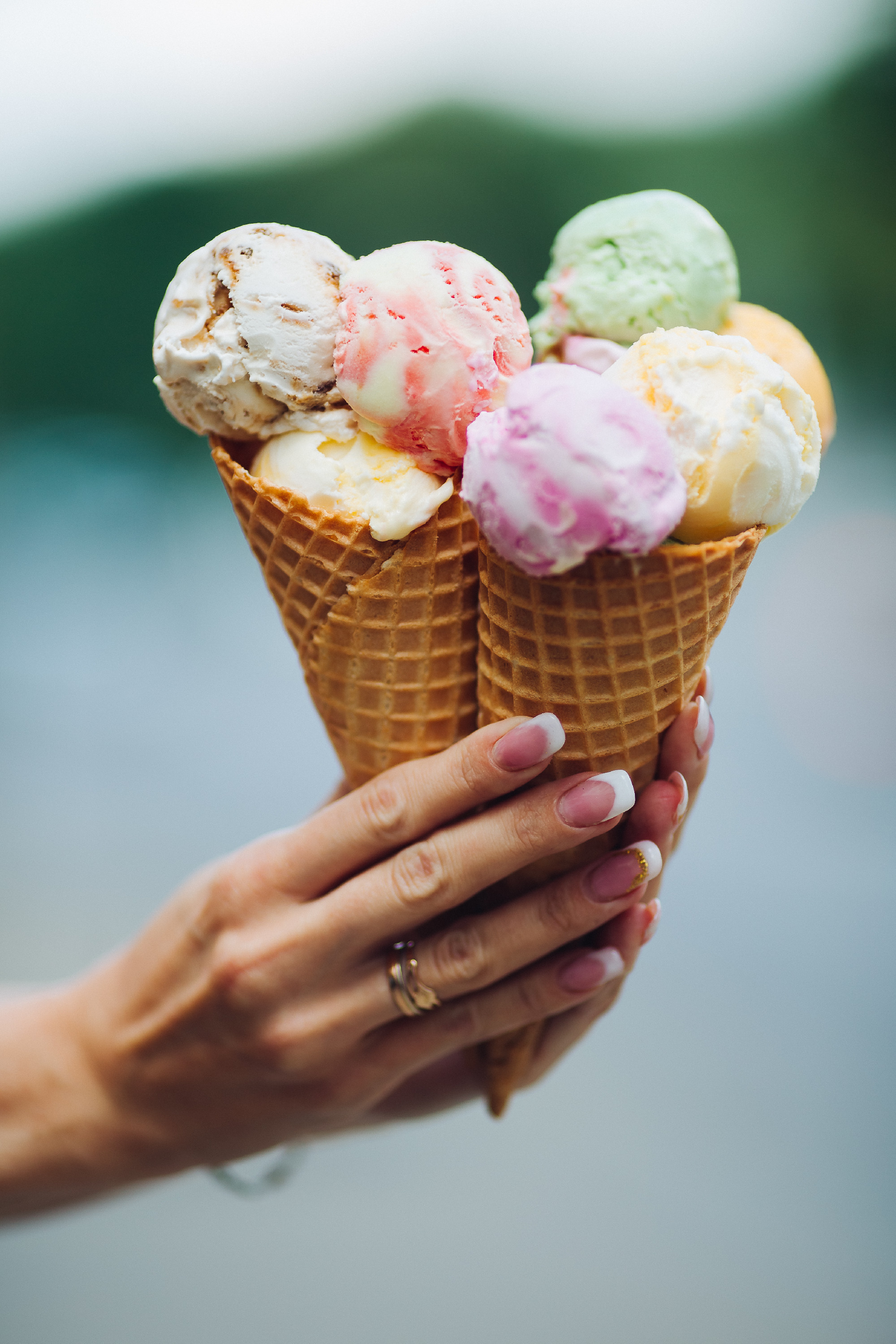 Crop of woman's hand holding delicious colorful ice cream.