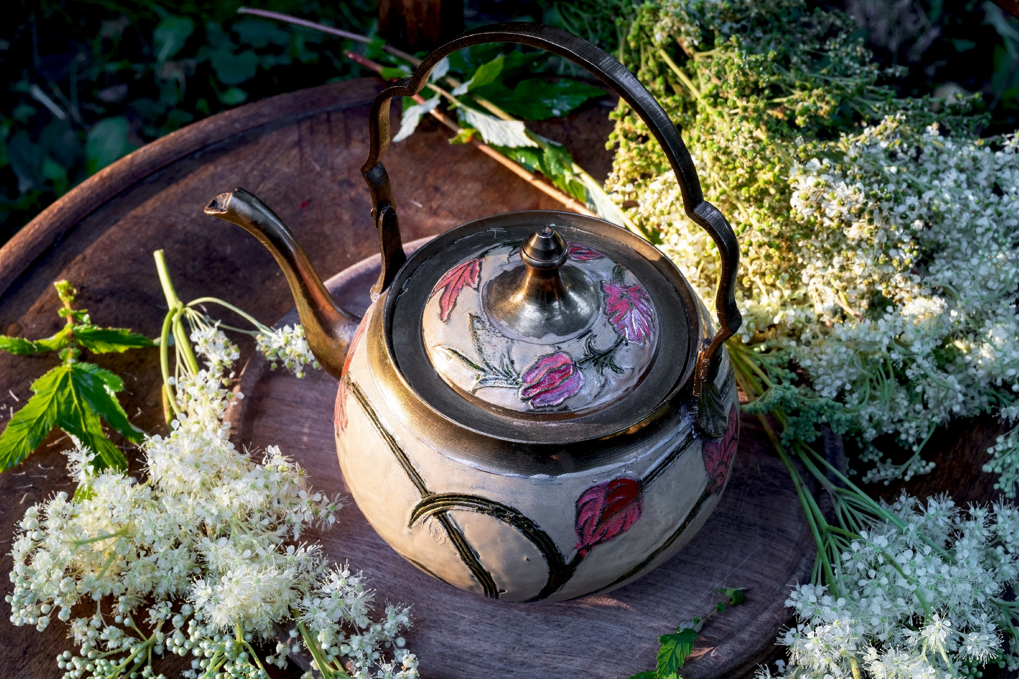 A teapot with fresh meadowsweet flowers