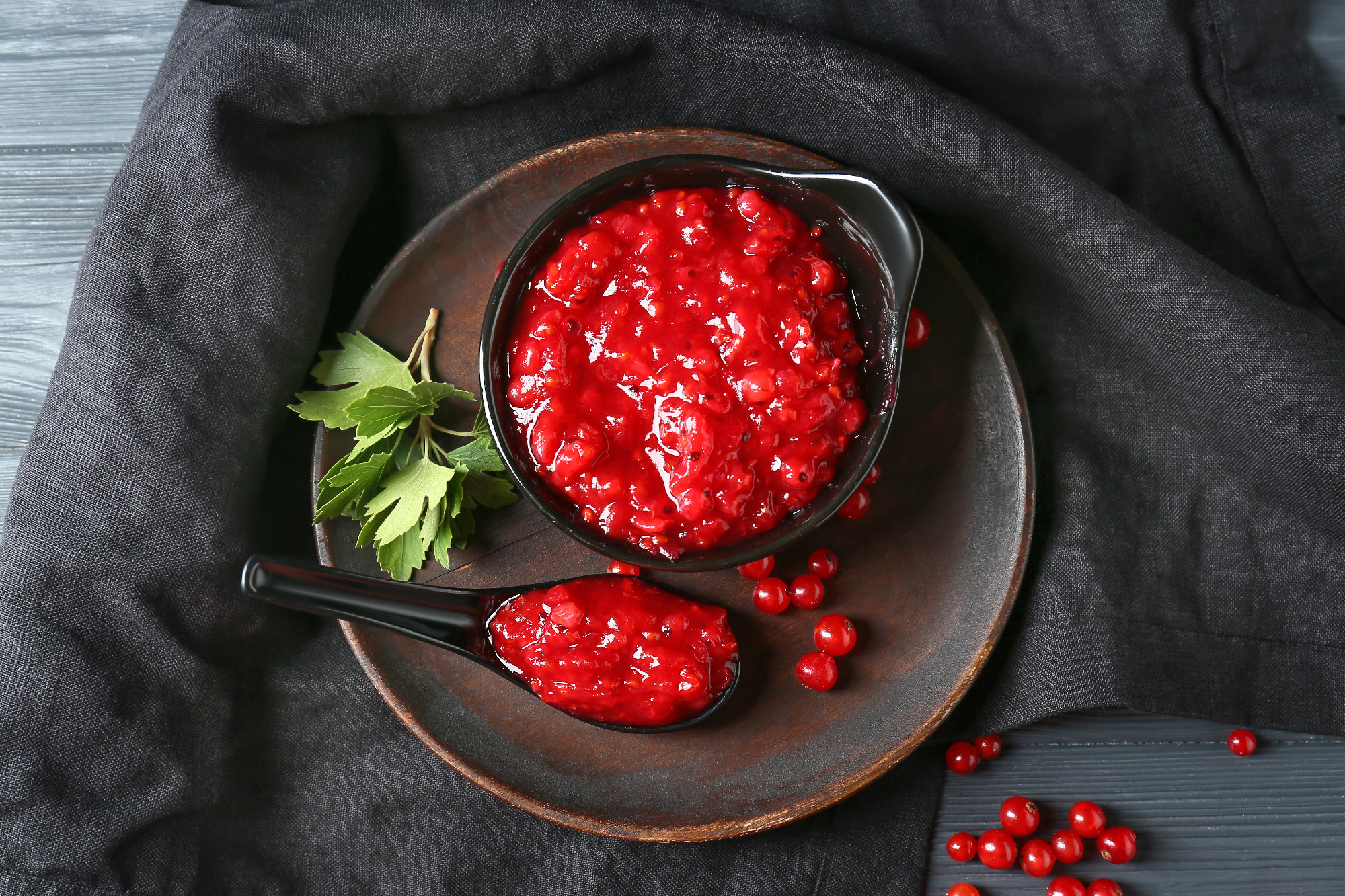 Composition with tasty red currant jam on dark wooden background�