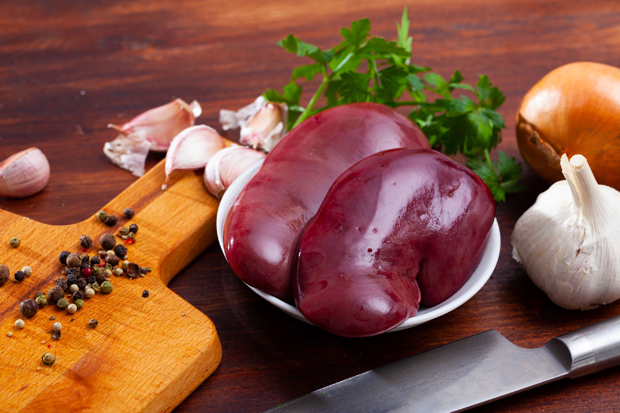 Cooking pork kidneys with parsley and garlic on the table