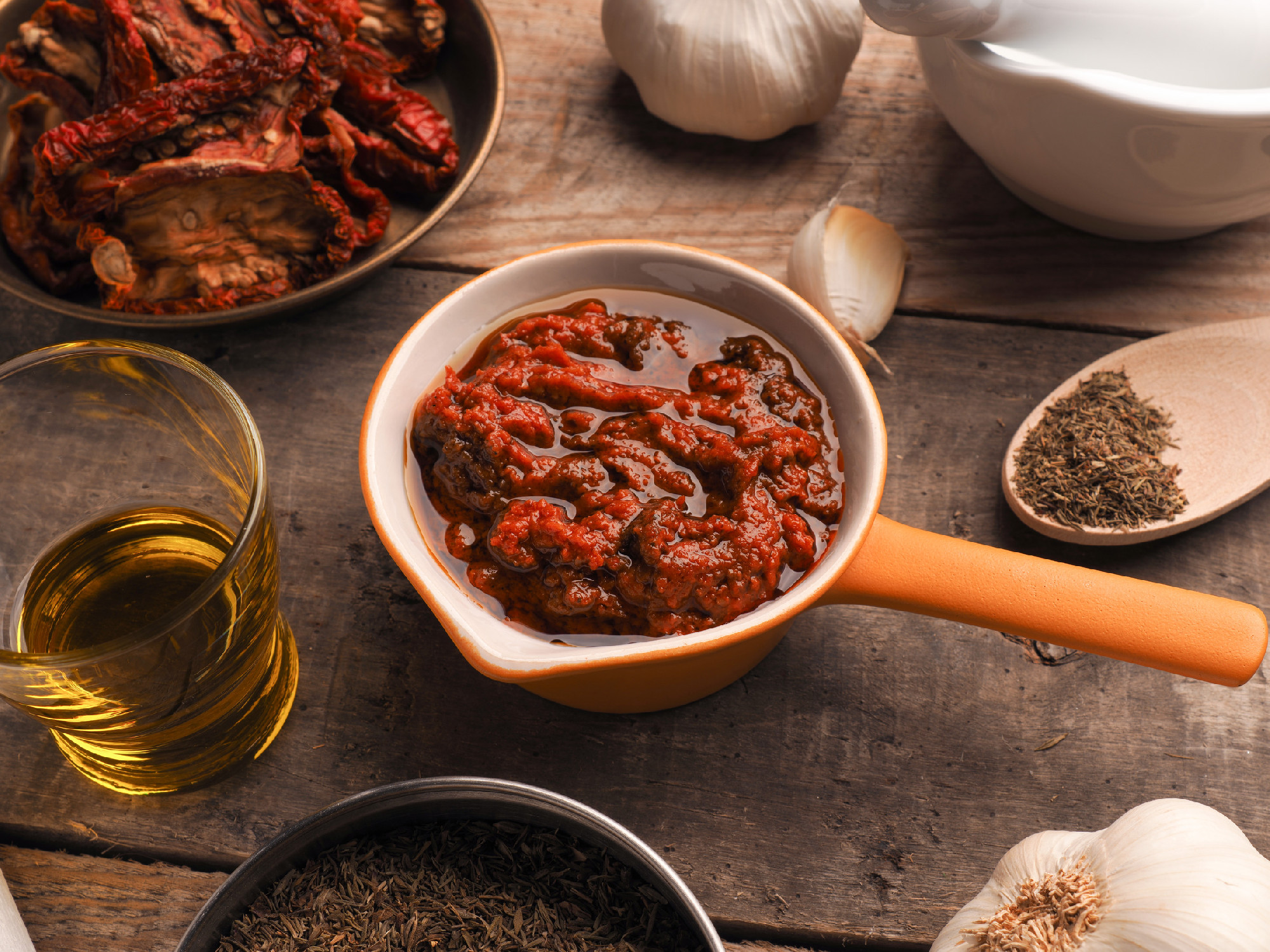 Tasty tomato pesto on a wrustic wooden table