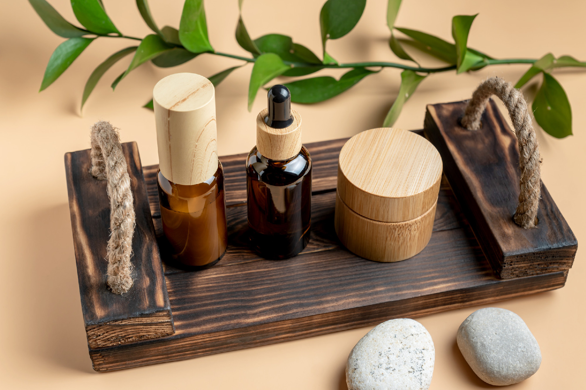 Cosmetics SPA branding mock-up. Dark glass cosmetic bottles and jars with onwooden tray on beige background. Natural organic beauty product concept, Minimalism style