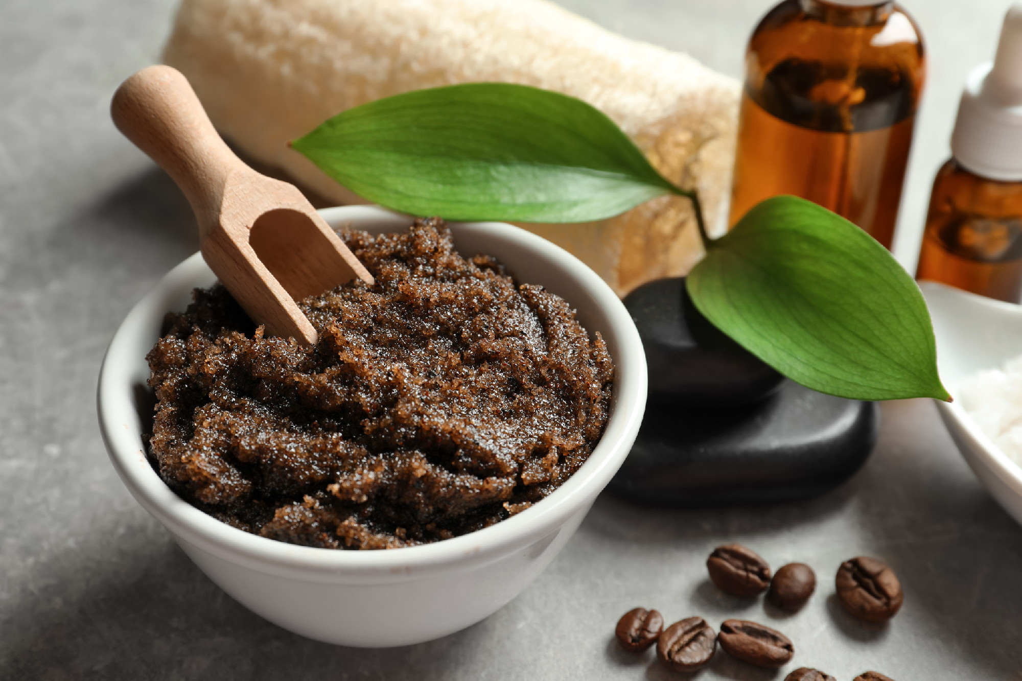 Bowl of coffee scrub with scoop on table�