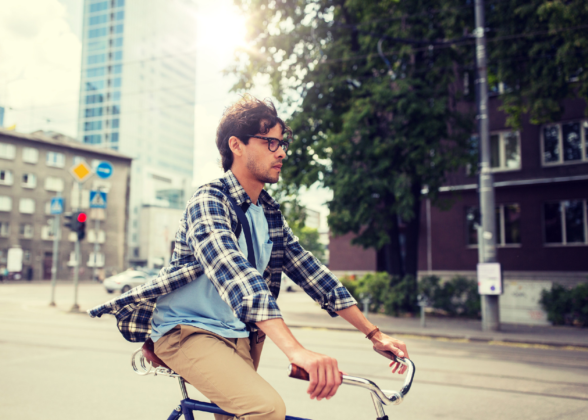 young hipster man with bag riding fixed gear bike