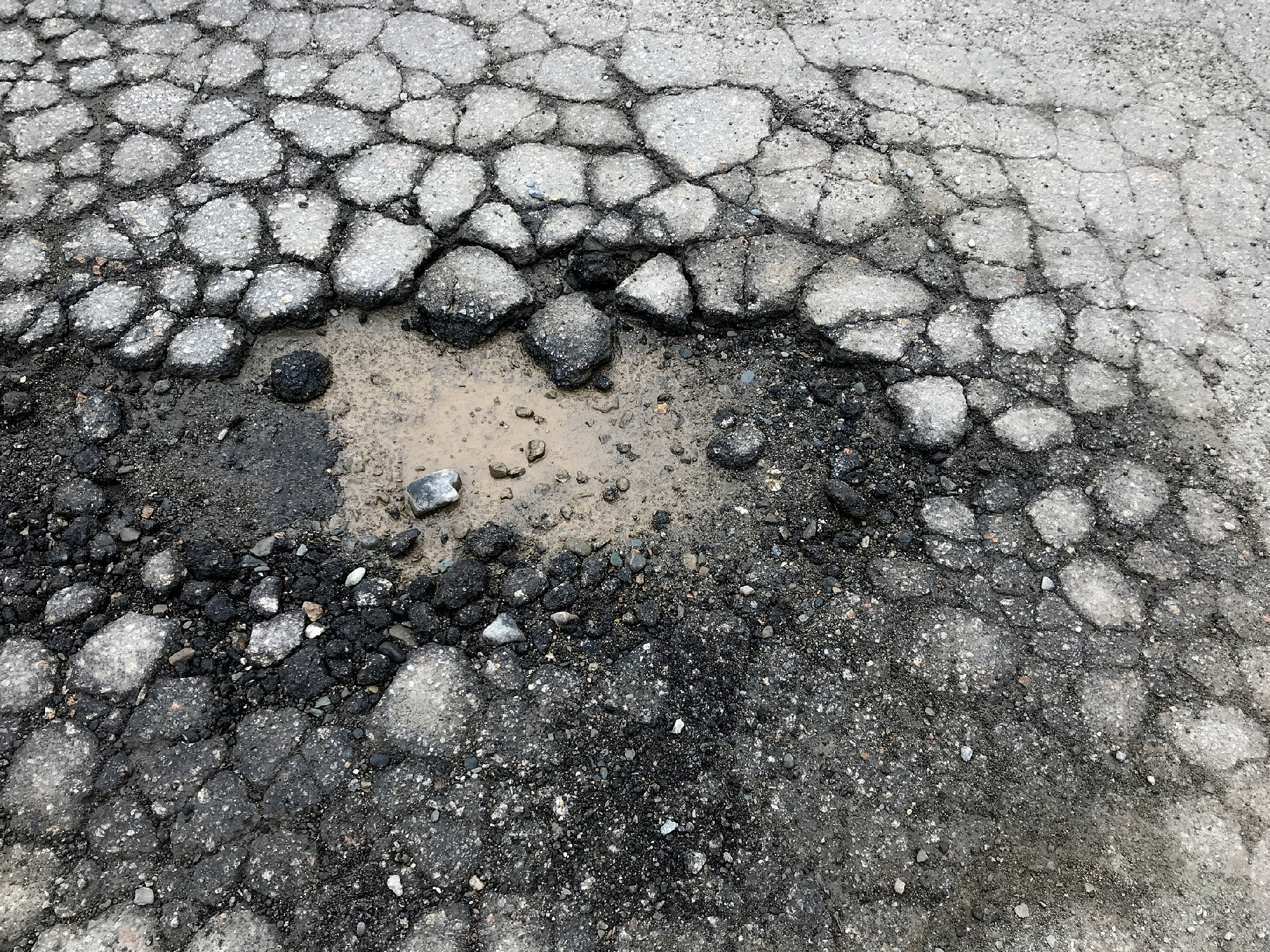 Asphalt pot hole in the summer