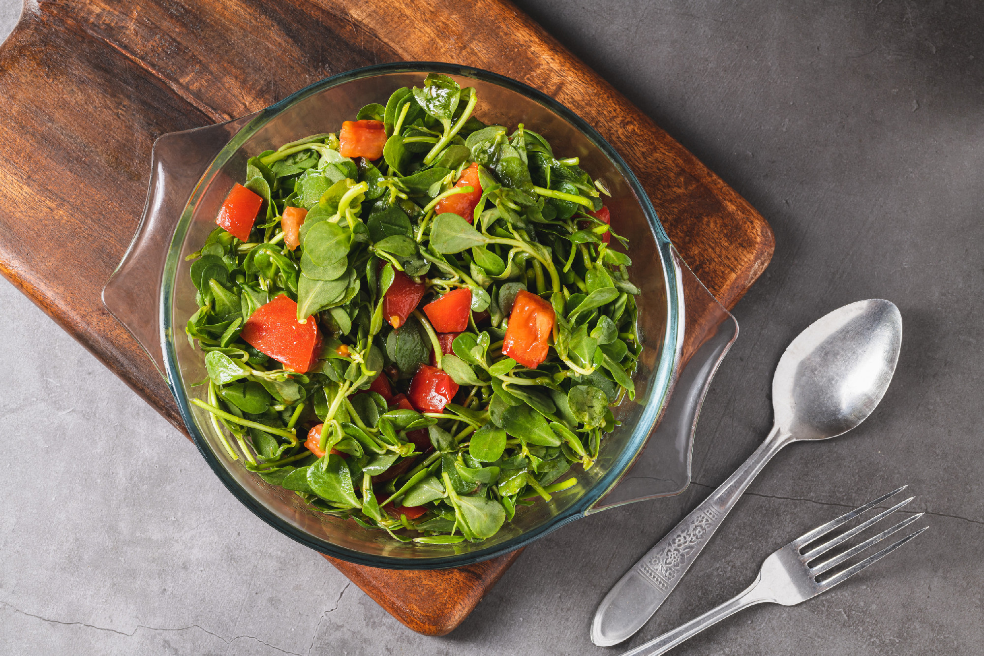 Purslane salad with tomatoes in a glass bowl. Healthy eating con