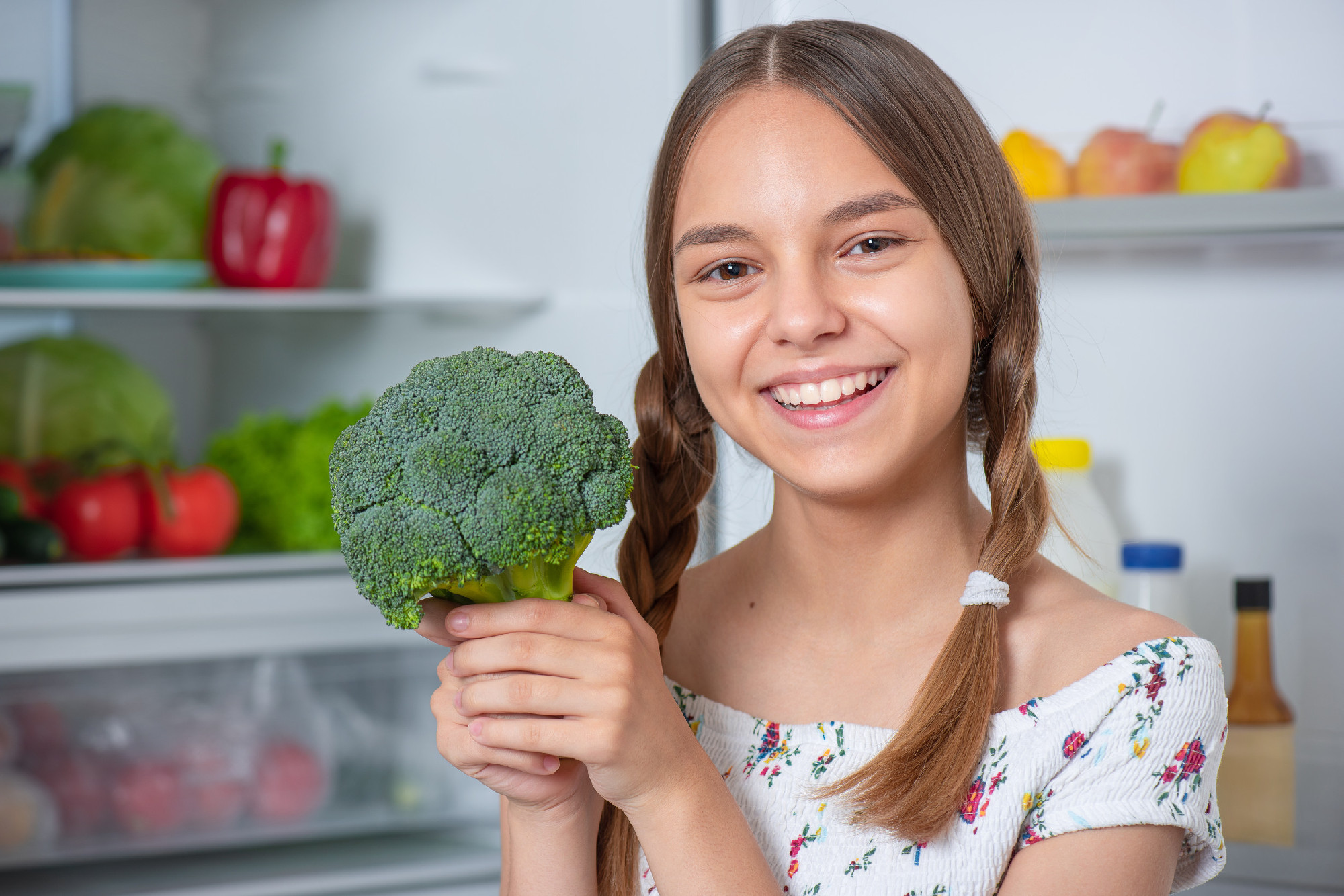 Girl with food near fridge