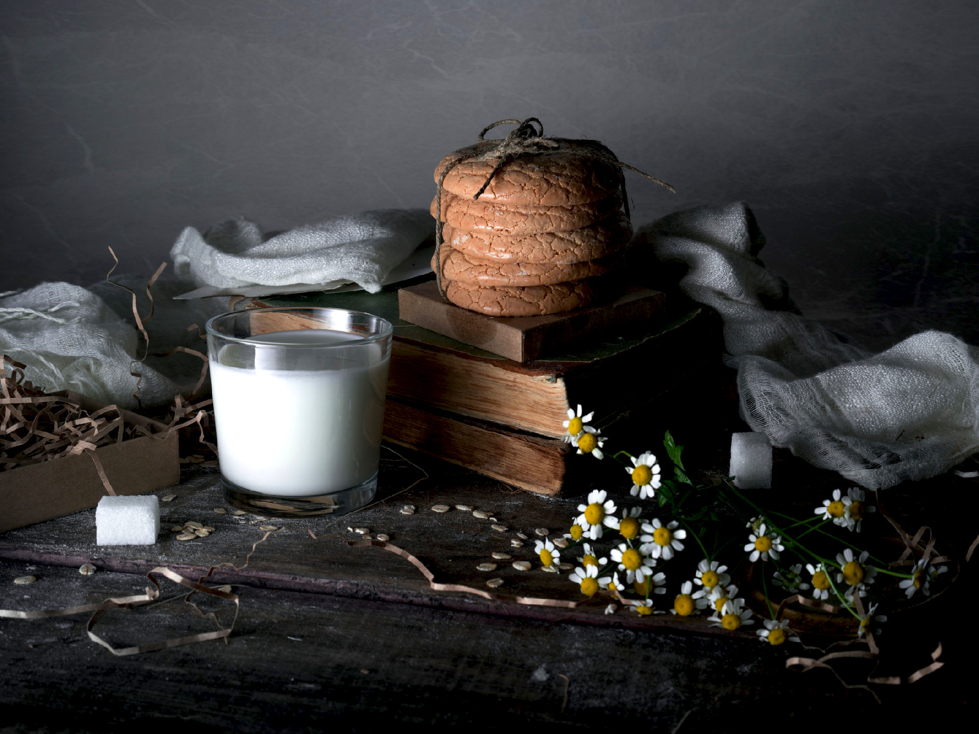 still life, vintage. old books, a glass of milk, cakes, drapery 