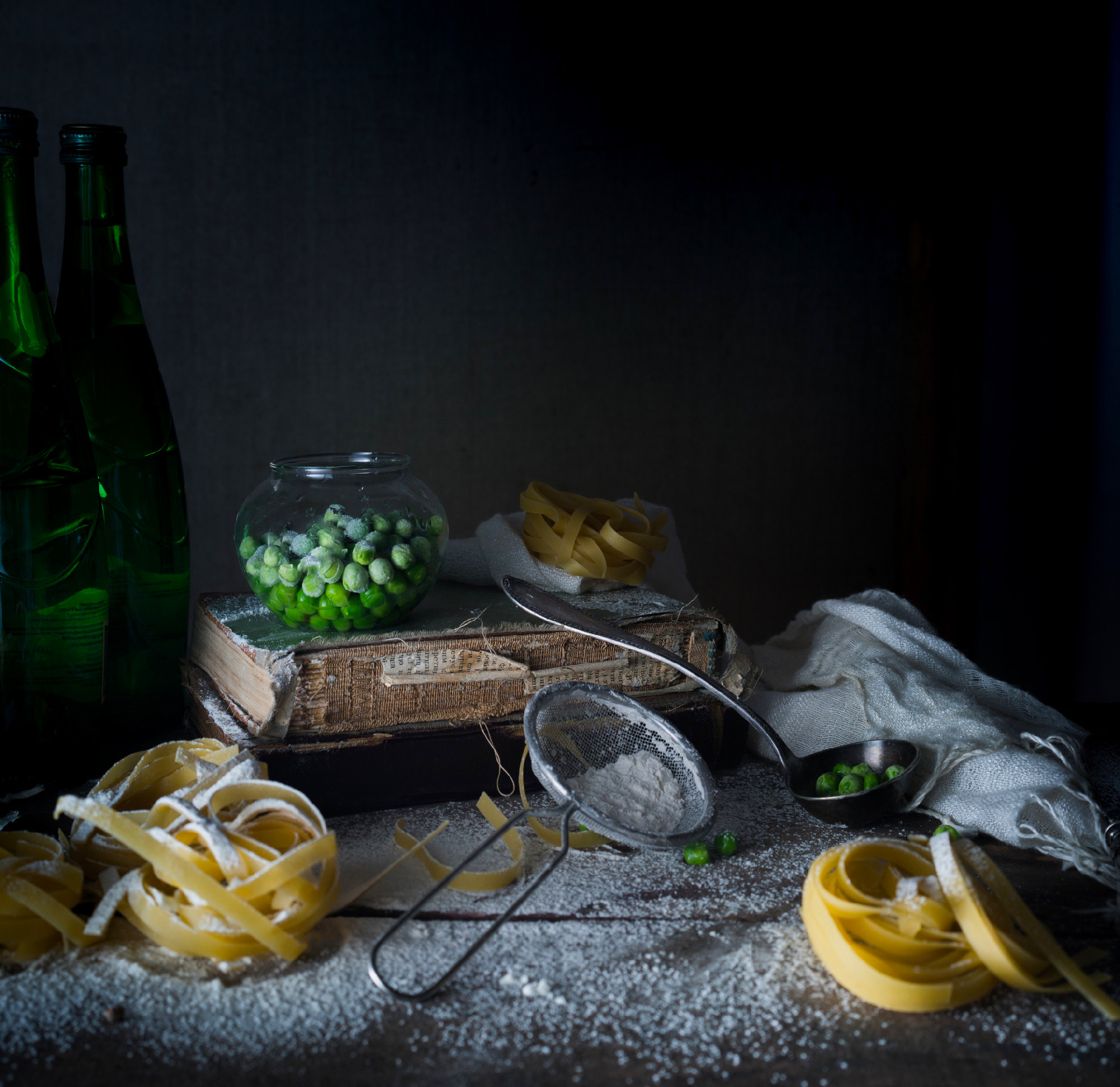 rustic still life, vintage. green peas, old books, flour on a wo