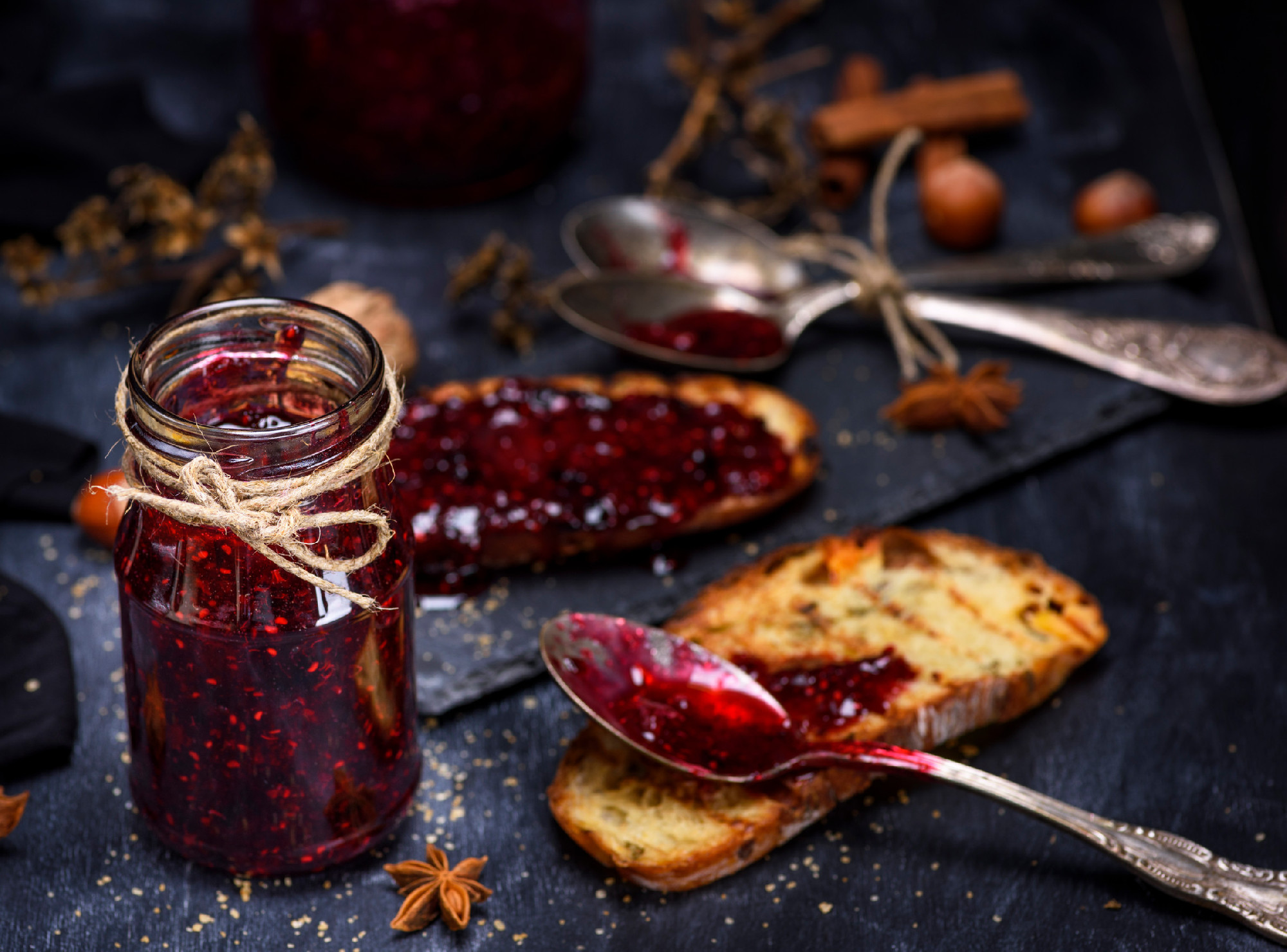  glass jar with raspberry jam and a slice of bread 