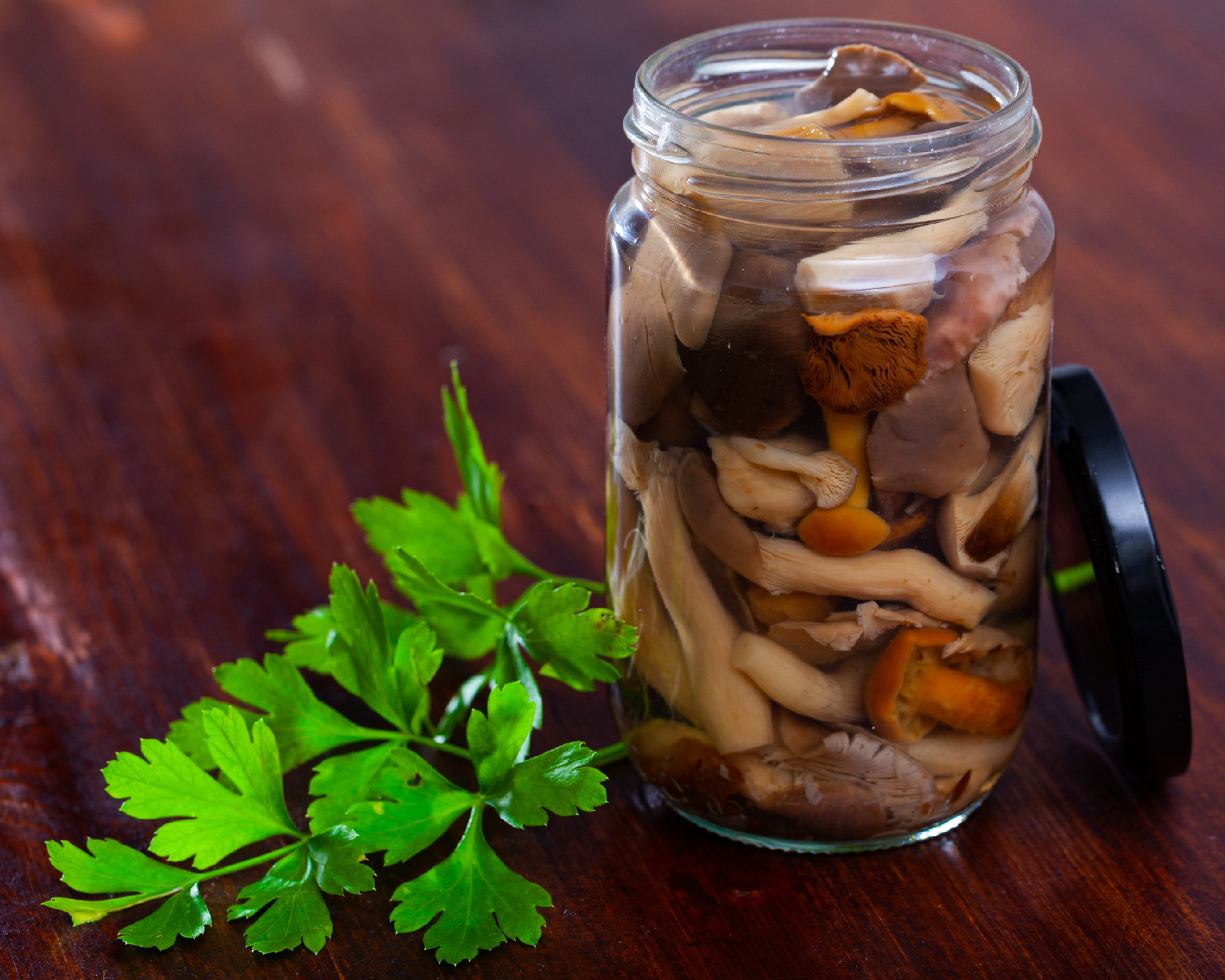 Assorted marinated mushrooms in glass jar