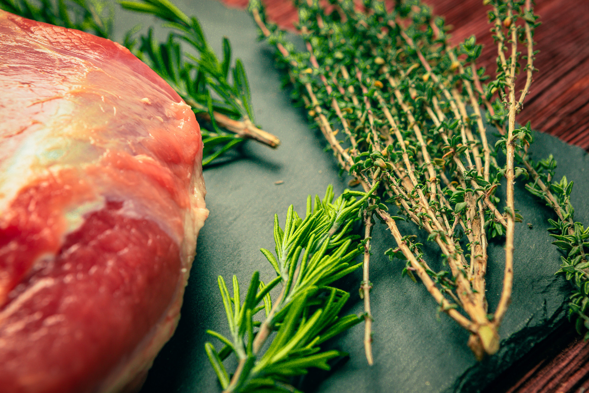 raw pork meat with spices on slate stone kitchen board