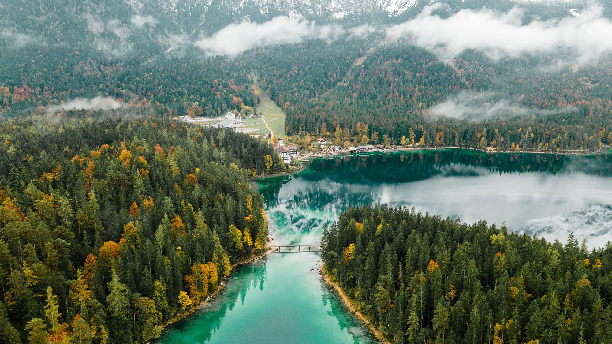 Autumn in the Bavarian mountains, Germany. Alps landscape with lake, bridge, view from above. Aerial drone photo.