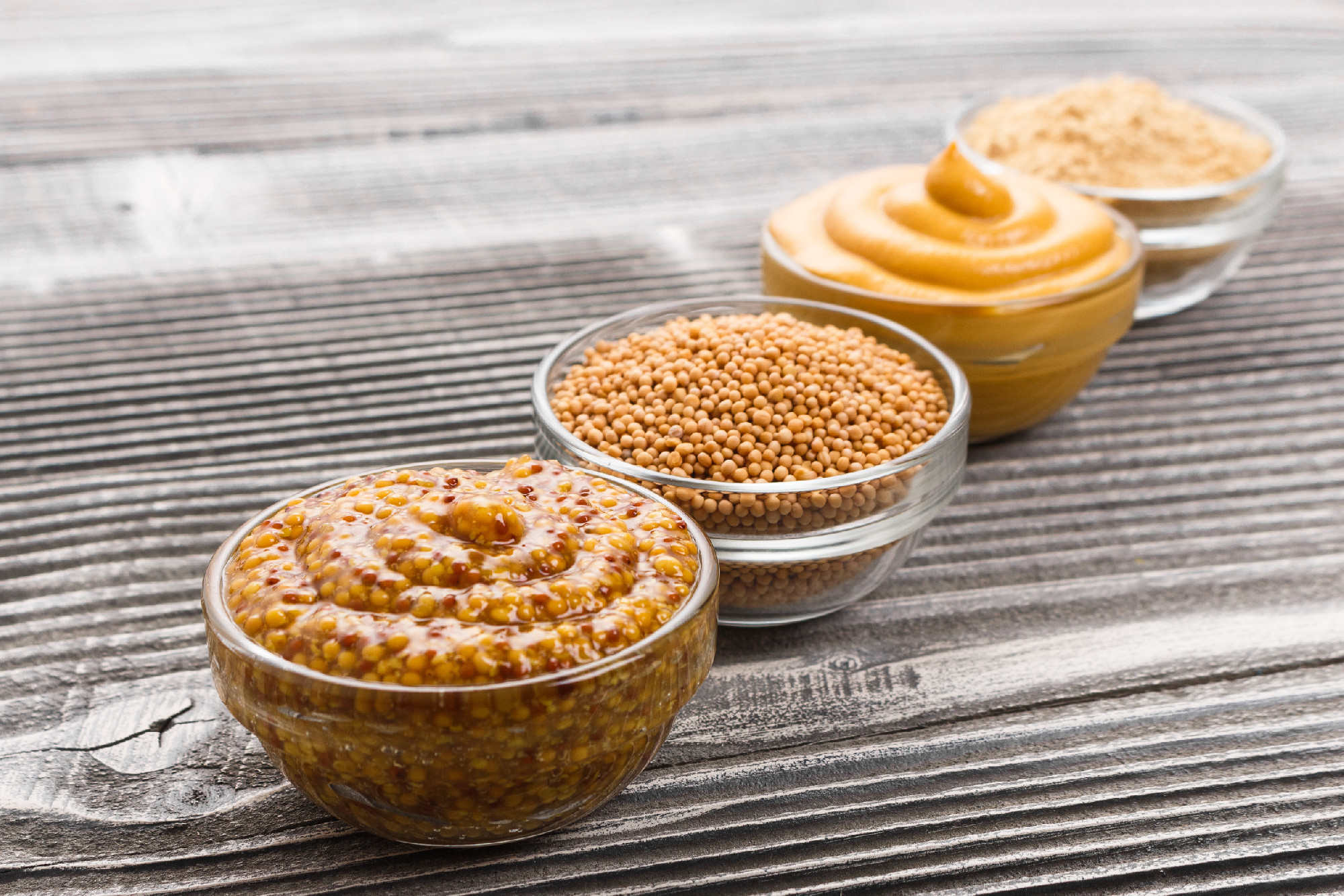 Set of different species of mustard on a rustic background