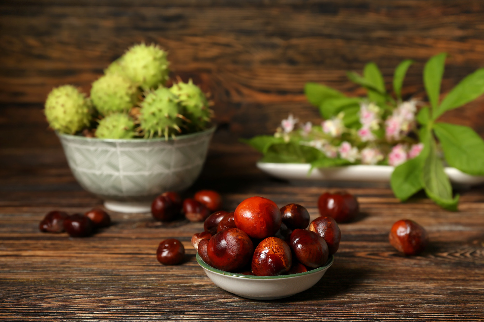 Bowl of fresh chestnuts on wooden background�