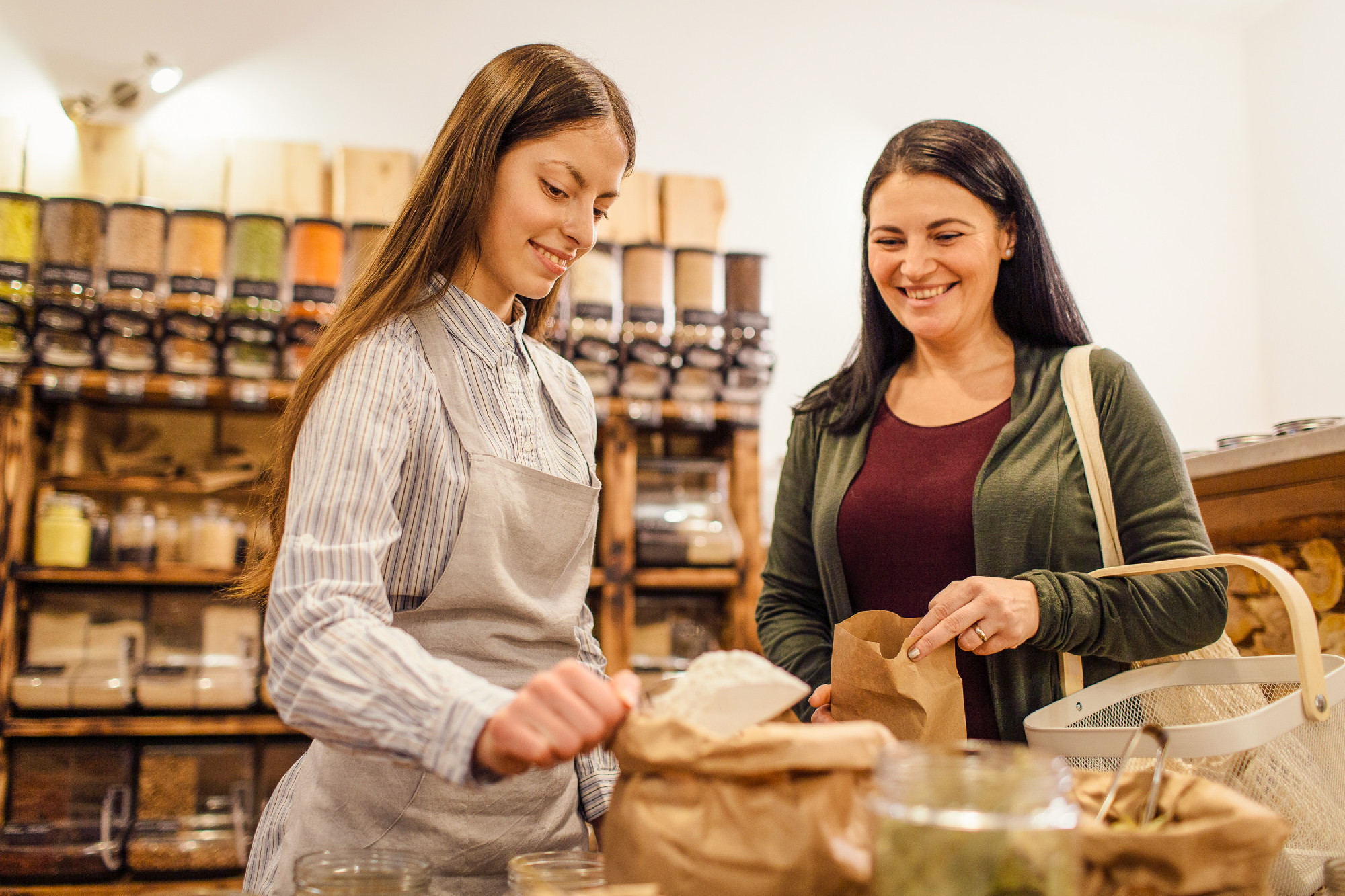 Zero waste shopping - woman buying flour at package free grocery