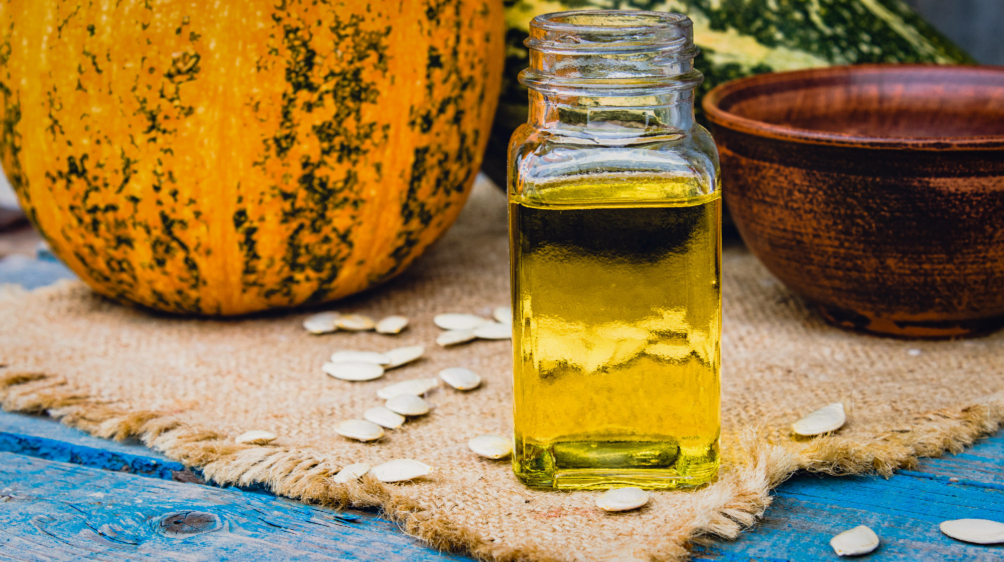 Closeup of a bottle of pumpkin seed essential oil on a napkin wi