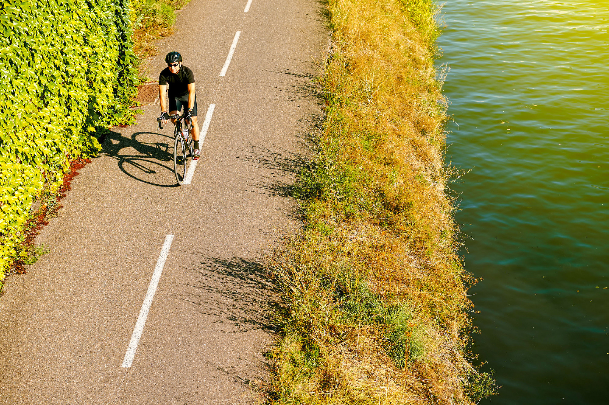 Adult man riding bike above aerial near river France