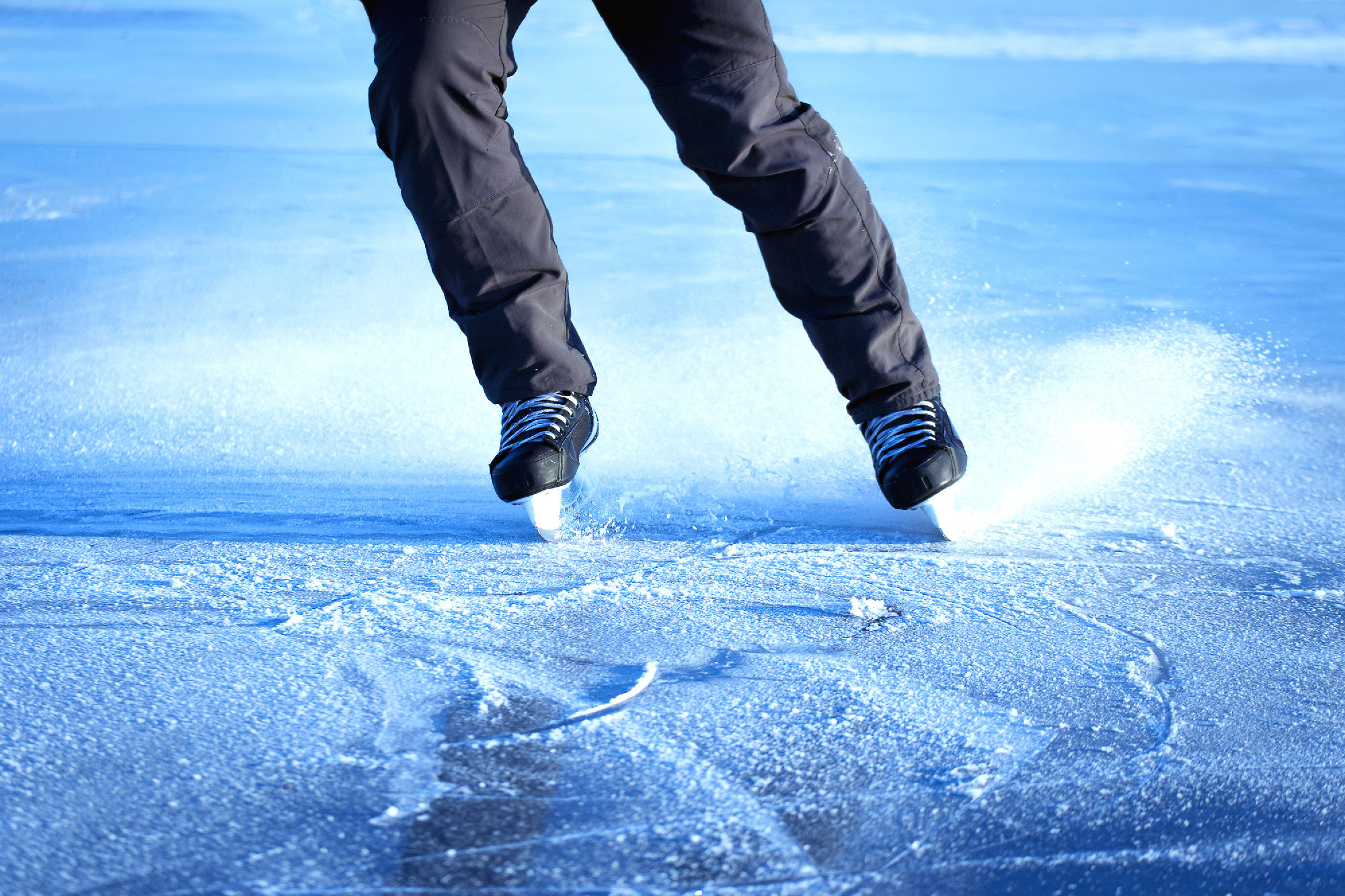 The guy rides on skates on ice in the winter.