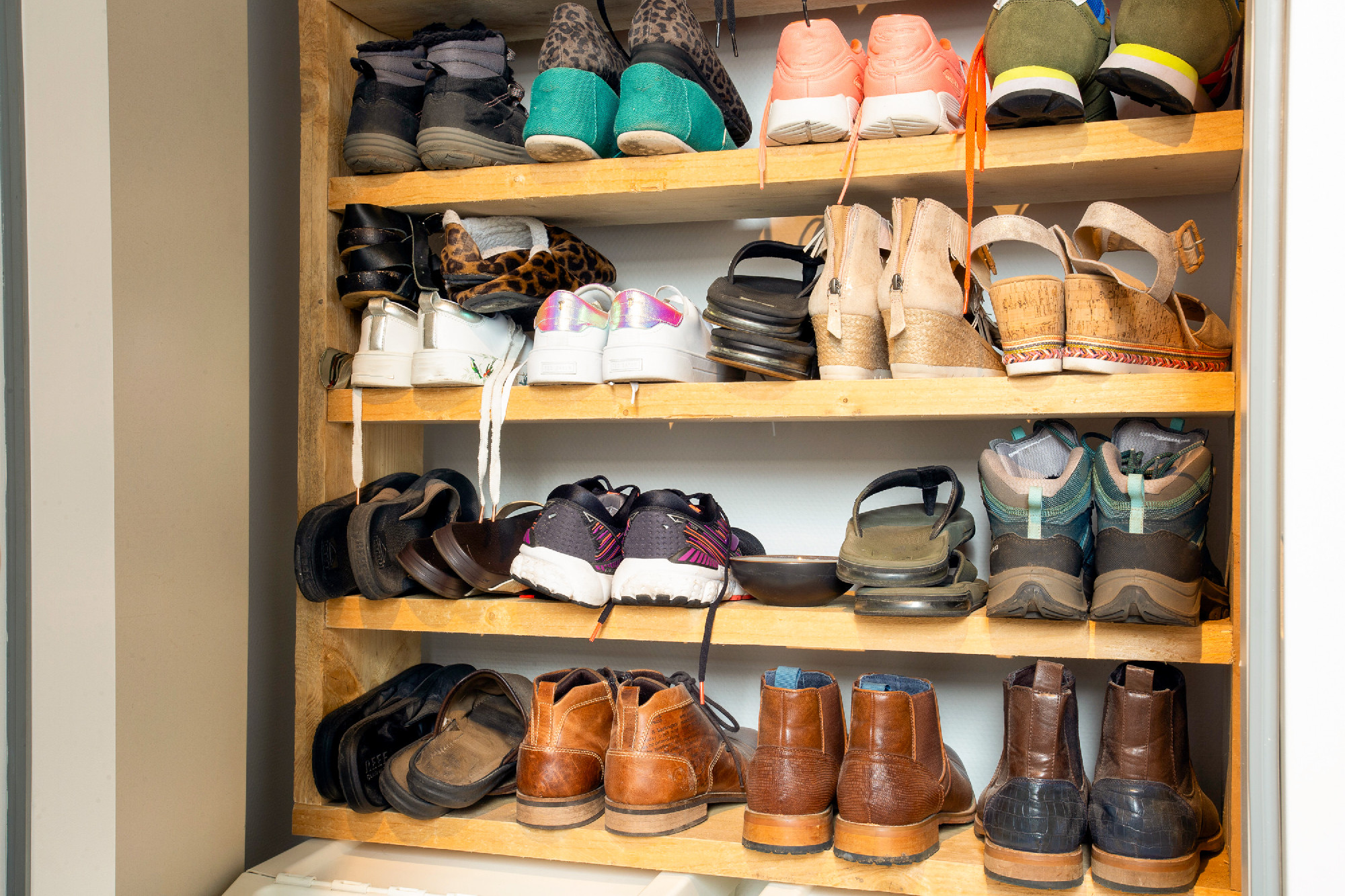 Collection of different shoes in shoe rack for storage, messy an