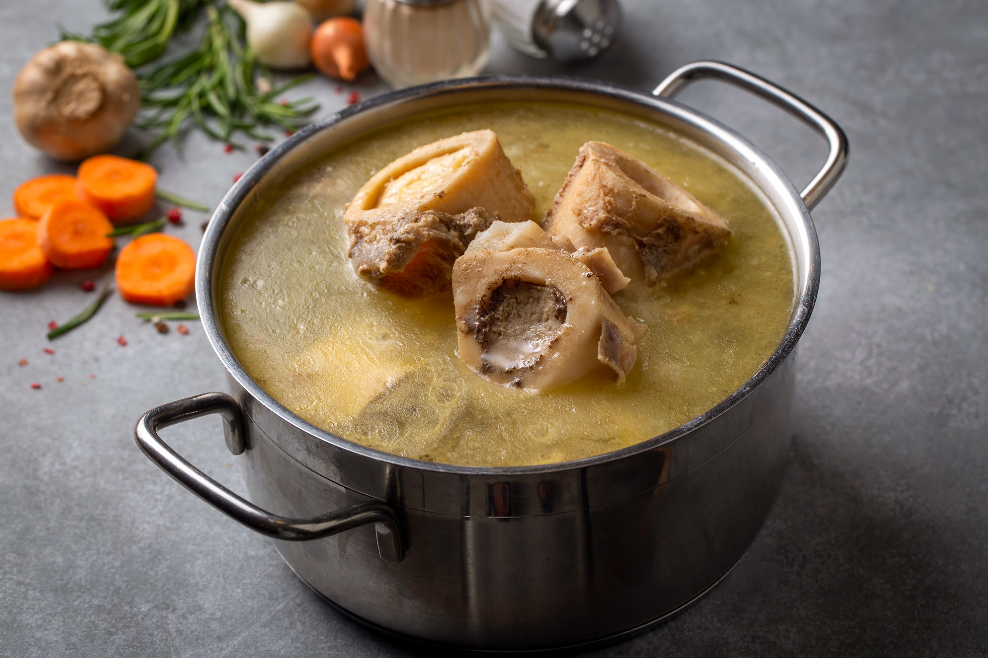 Boiled bone and broth. Homemade beef bone broth is cooked in a p