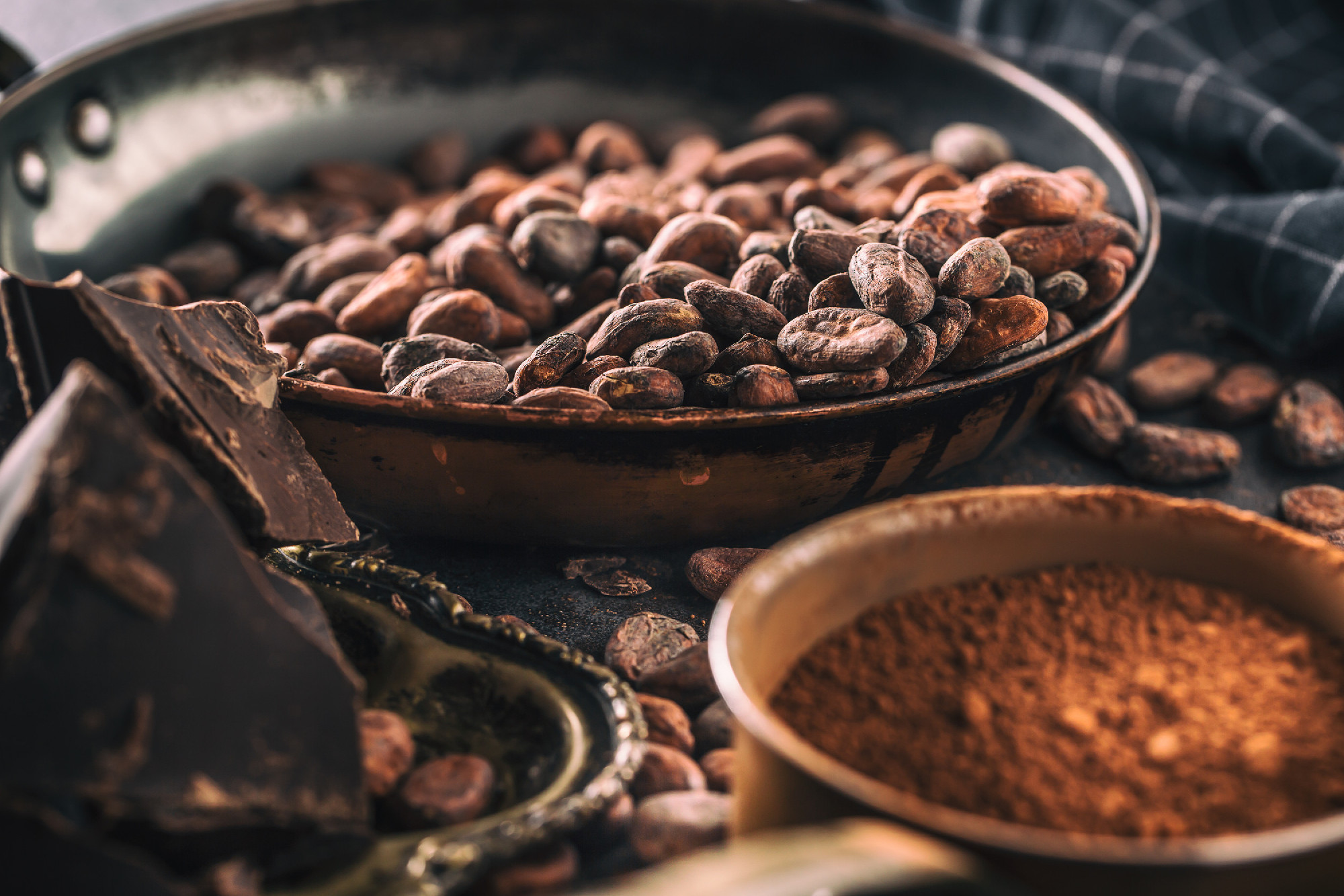 Dark chokolate cocoa beans and powder on concrete table