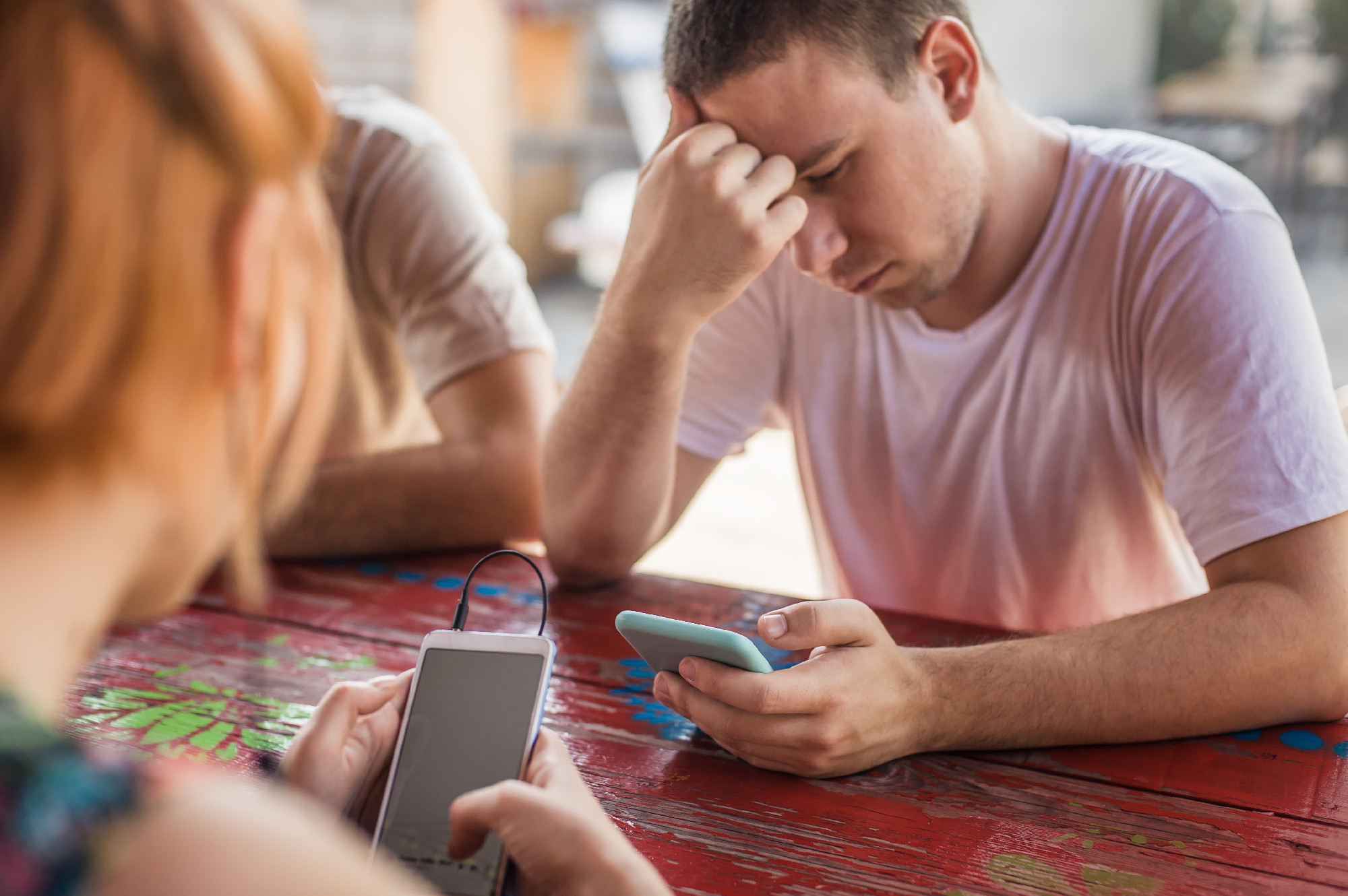 Alienation addiction. Friends sitting in cafe, typing on their p
