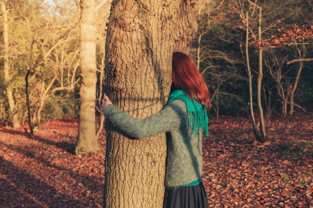 Woman hugging tree at sunset