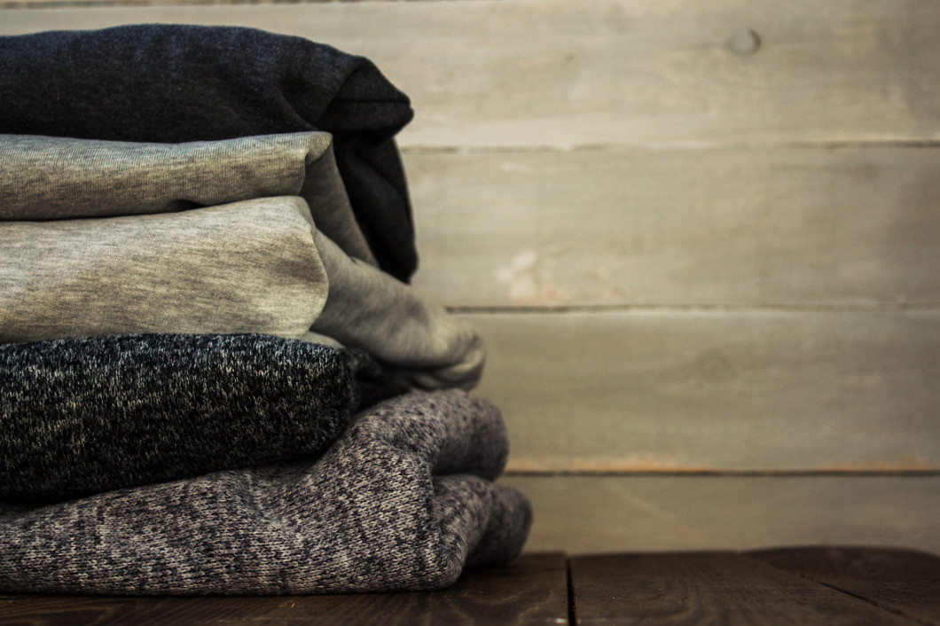 a stack of sweter on a wooden background