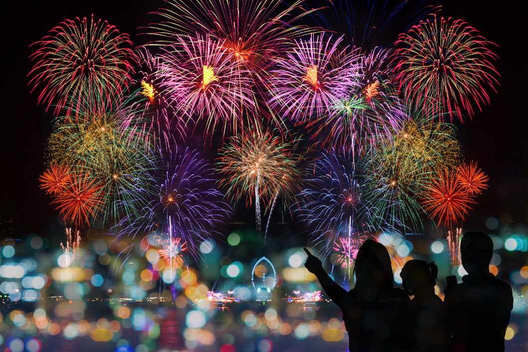 The happy family looks celebration fireworks on the night sky